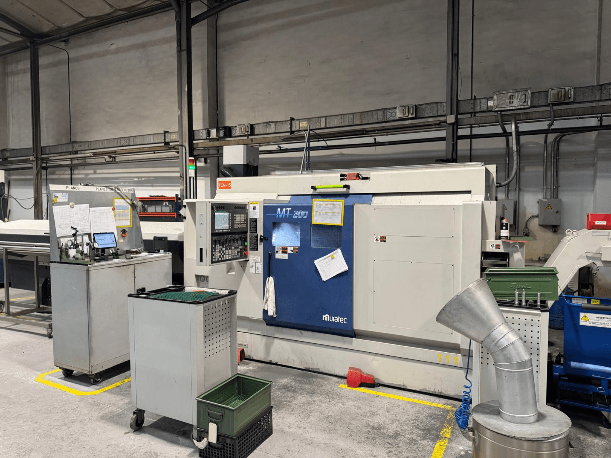 Muratec MT200 viševretenasti tokarski stroj u tvorničkom okruženju, gledan sprijeda, s upravljačkom pločom i okolnom opremom.