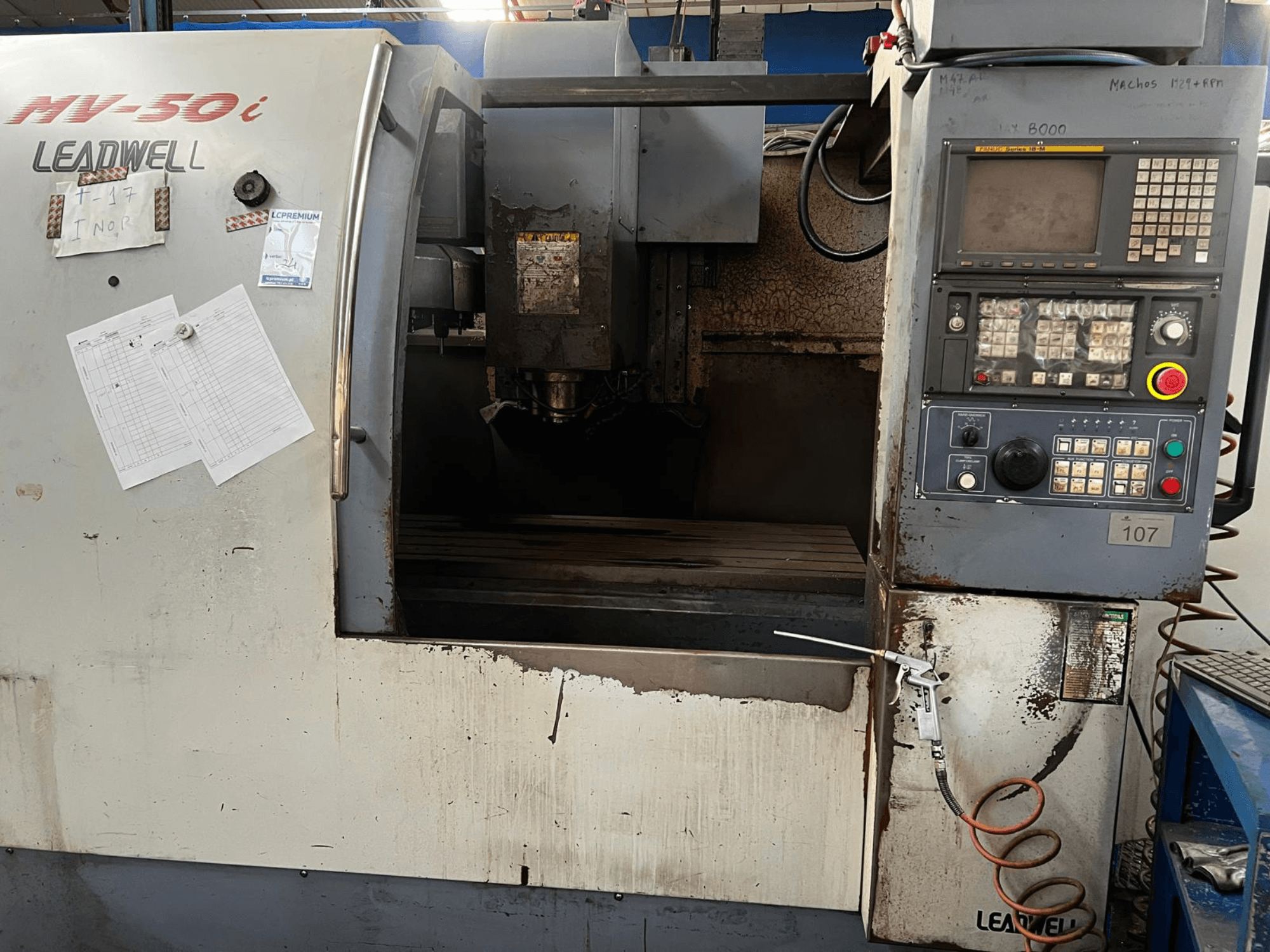 Vertikalni obradni centar Leadwell MV-50i, prednji pogled, prikazuje upravljačku ploču, područje vretena i radni stol s istrošenim dijelovima.