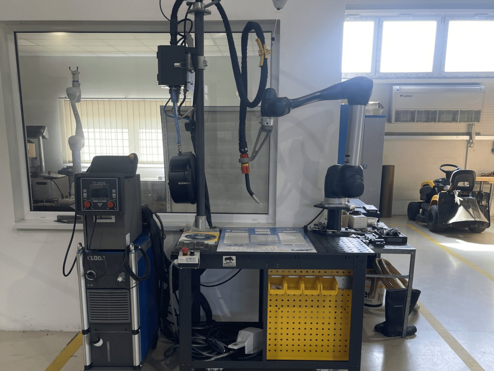 DOOSAN M1013 kolaborativni robot u radionici, bočni pogled s opremom za zavarivanje i alatima na radnom stolu.