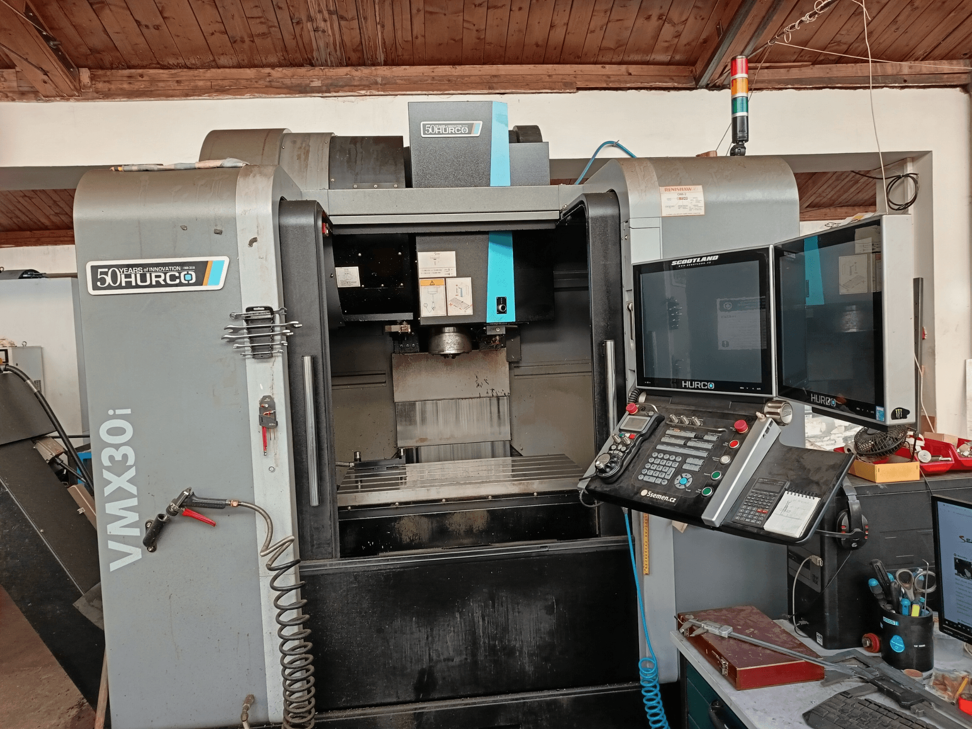 Hurco VMX30i CNC glodalica s prednje strane, s dva monitora, upravljačkom pločom i priključenim crijevom.