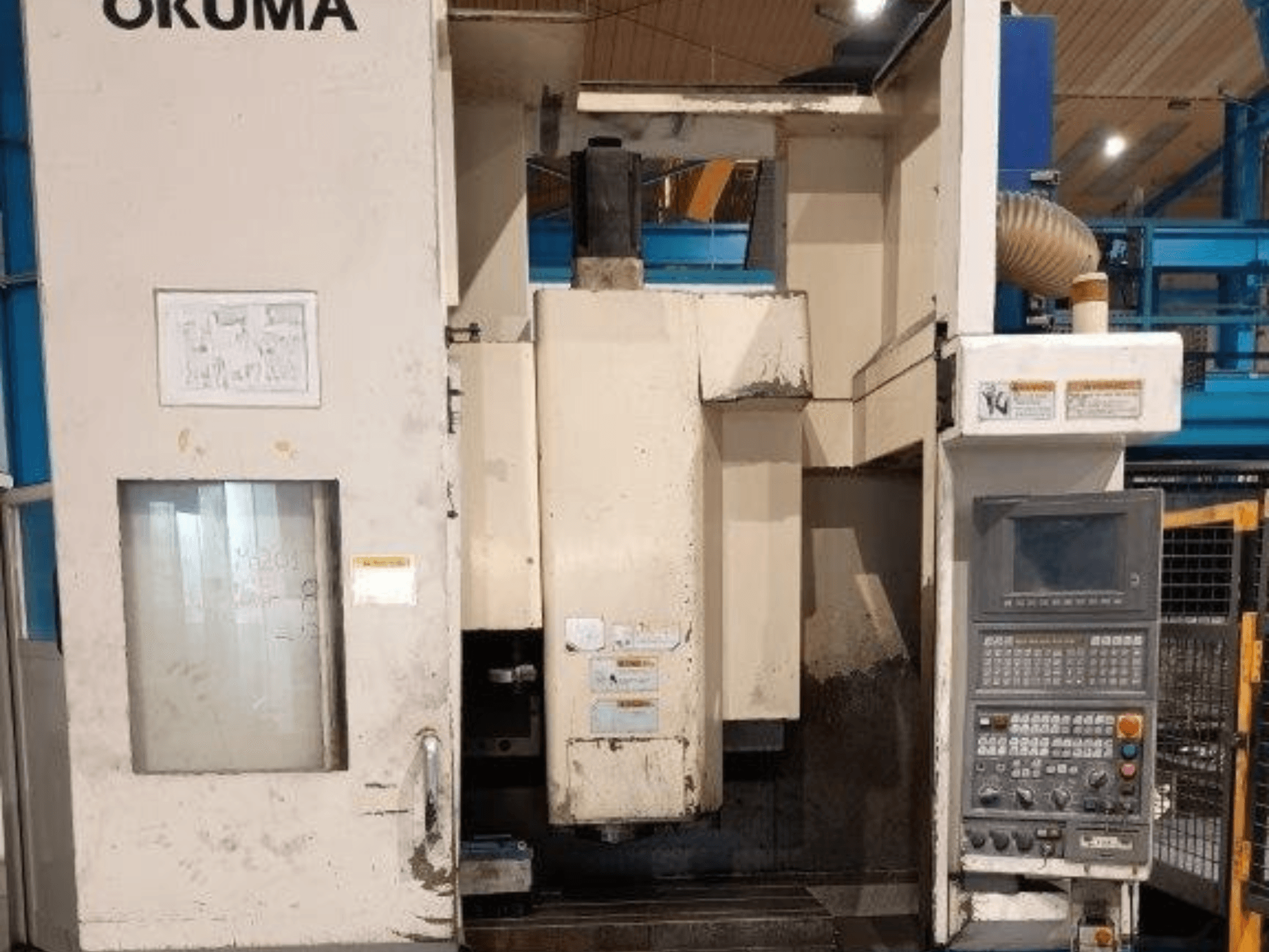 Okuma CNC glodalica, prednji pogled, ima upravljačku ploču s gumbima, zaslon i vidljive oznake na kućištu stroja.