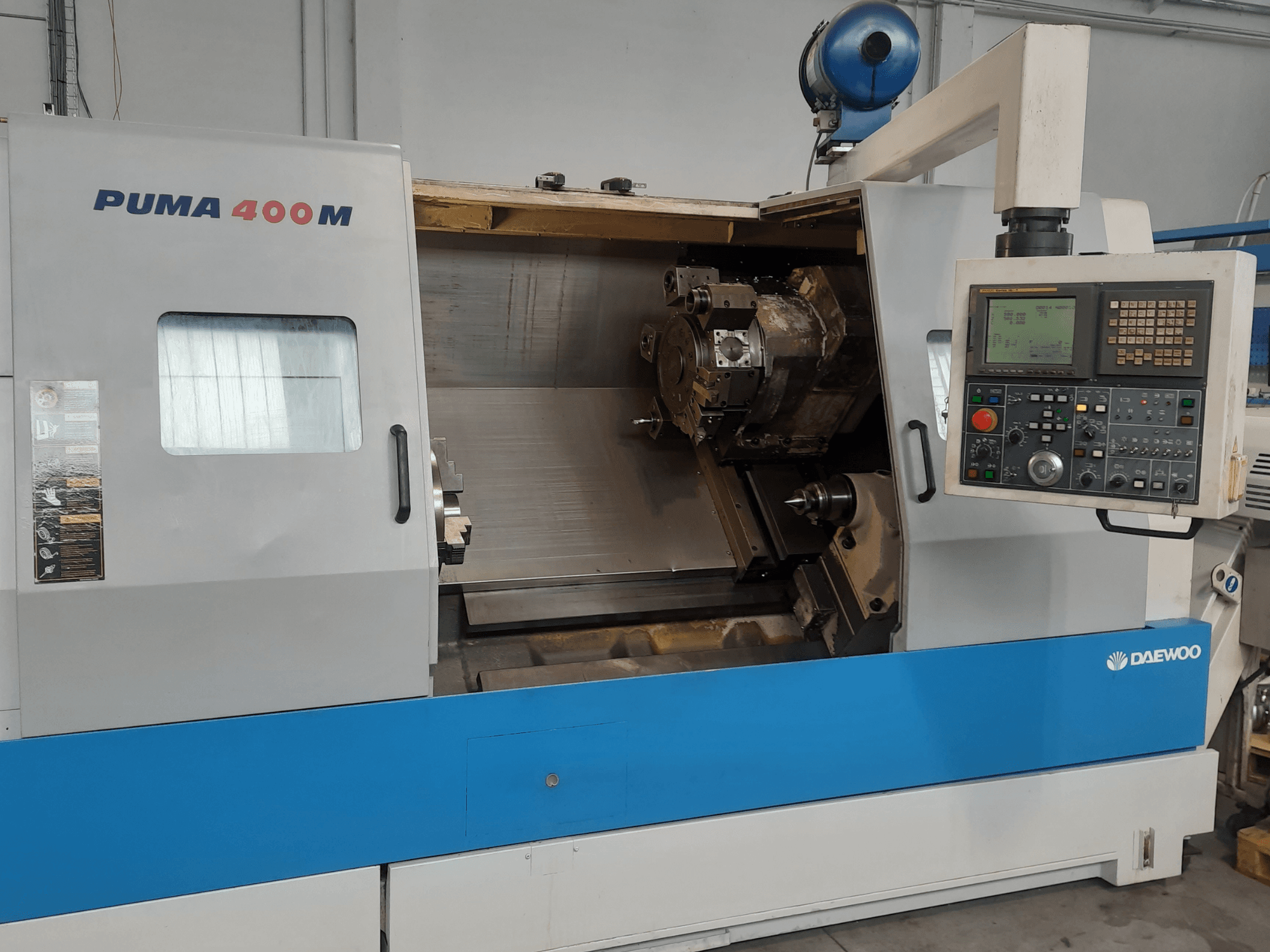 Prednji pogled na horizontalni tokarski stroj DAEWOO PUMA 400MB, s prikazom kontrola i alata za rezanje u komori.