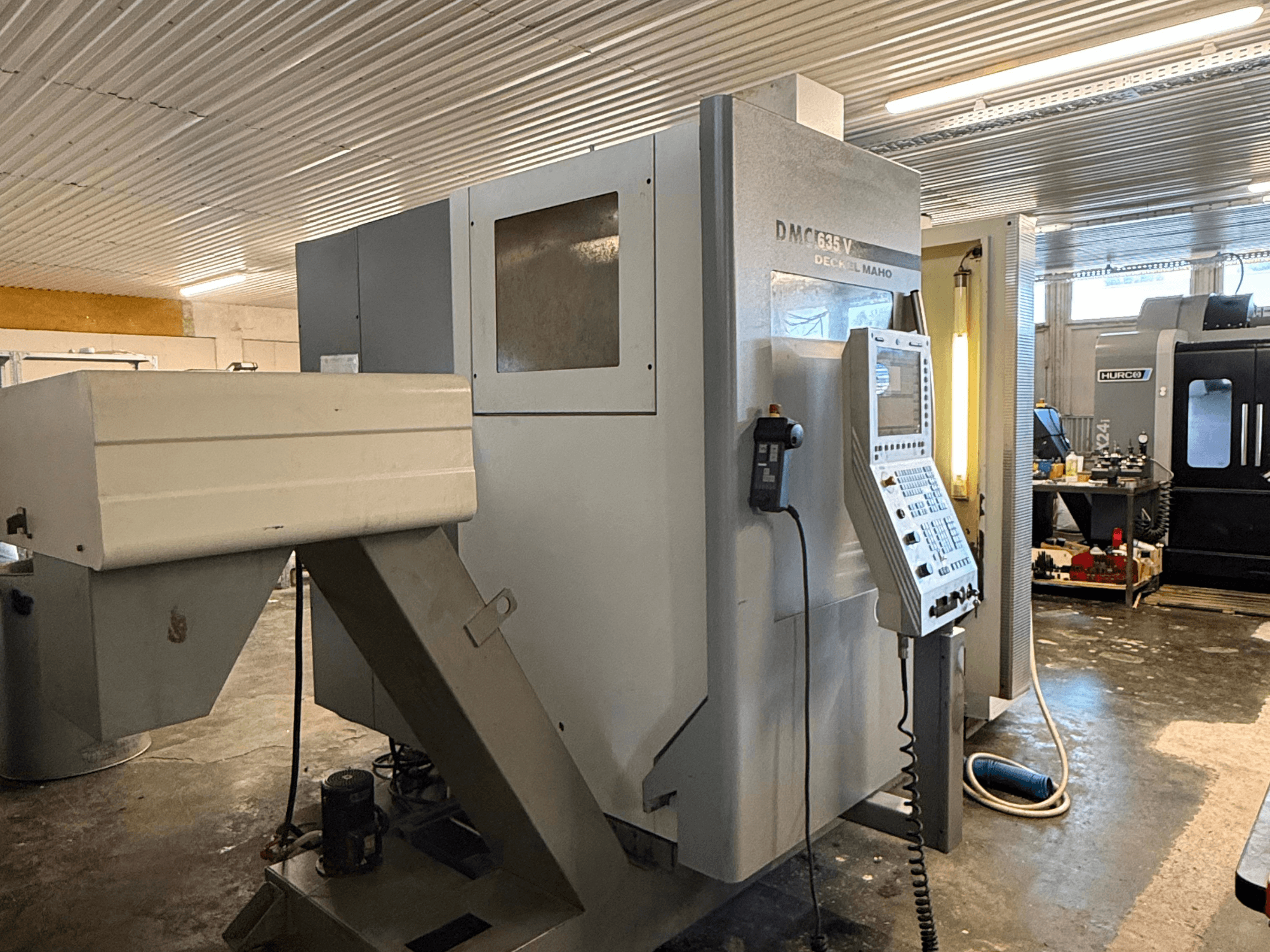 Glodalica DMC G635V u radionici, prednji pogled s vidljivom upravljačkom pločom i priključenim električnim alatima.