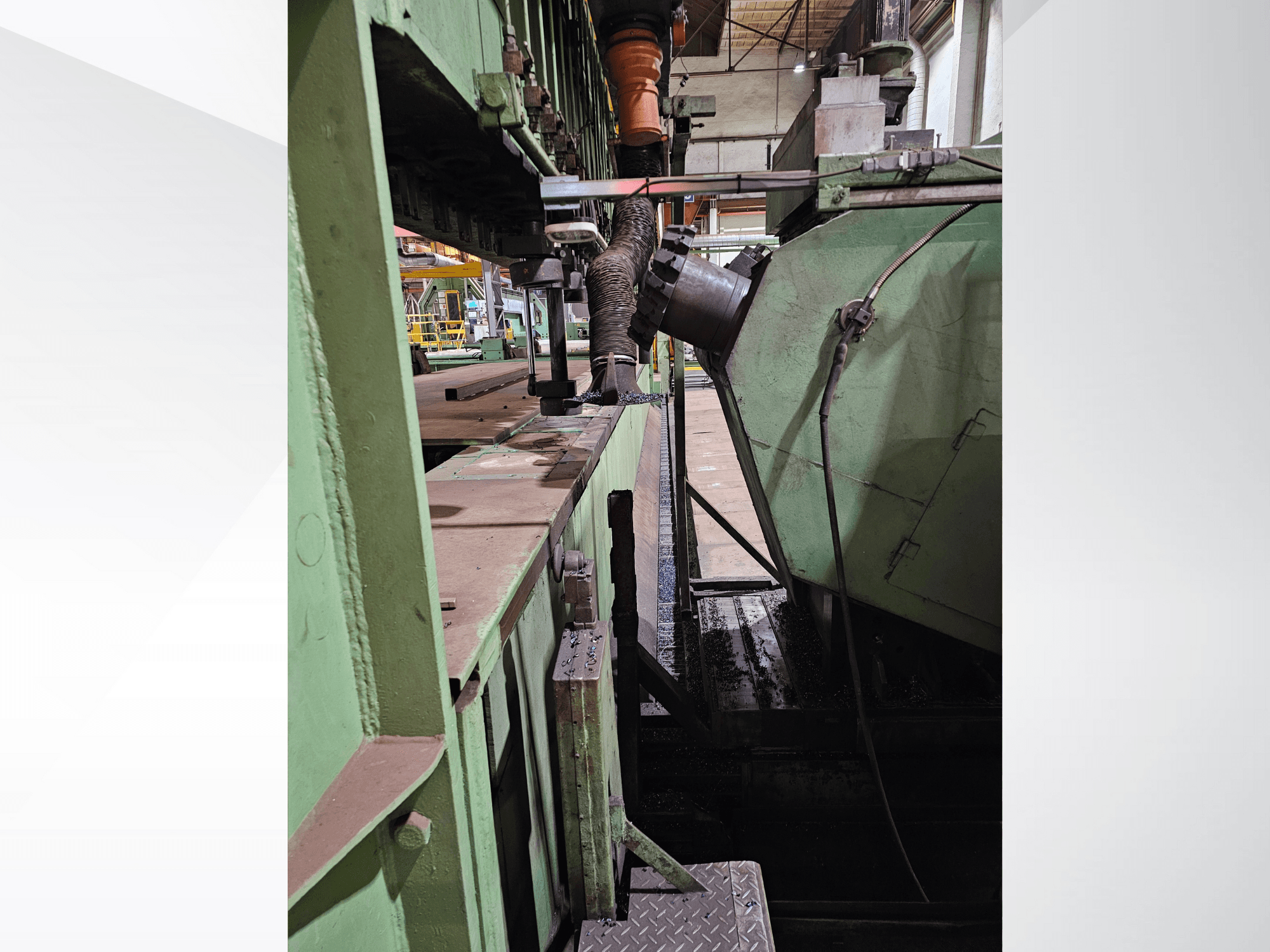 Zeleni industrijski strojevi s bočnim pogledom na lijevak i mehanizam za punjenje, s metalnim komponentama i platformom.