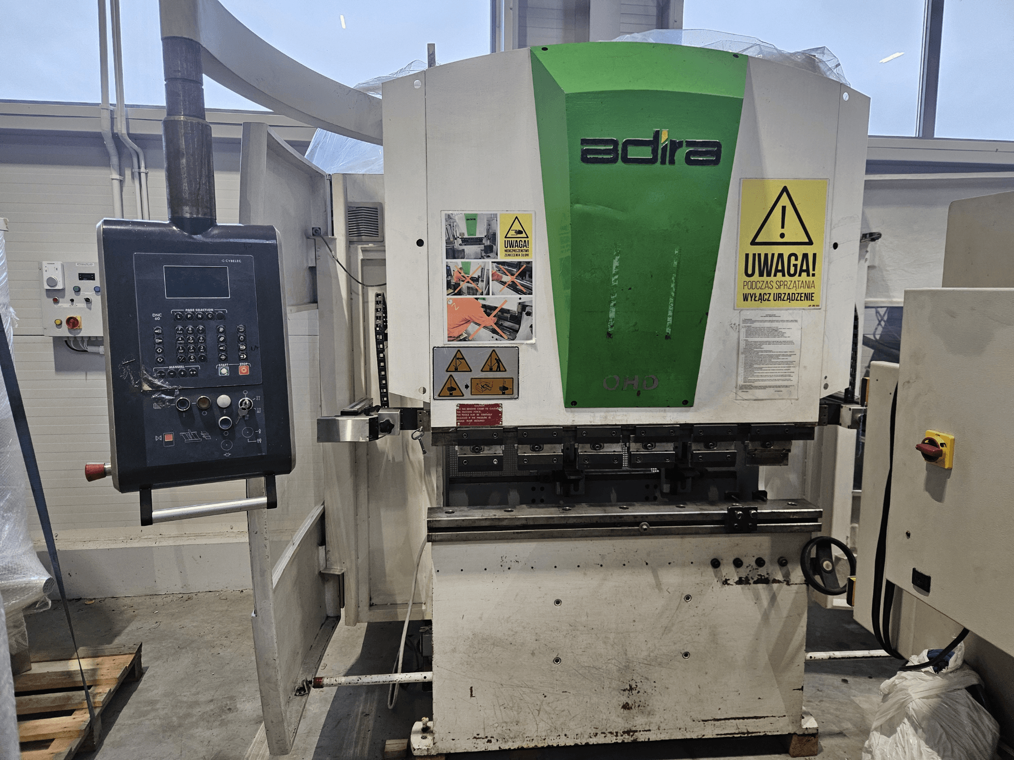 Adira OHD stroj gledan sprijeda, s upravljačkom pločom, sigurnosnim upozorenjima i operativnim tipkama.