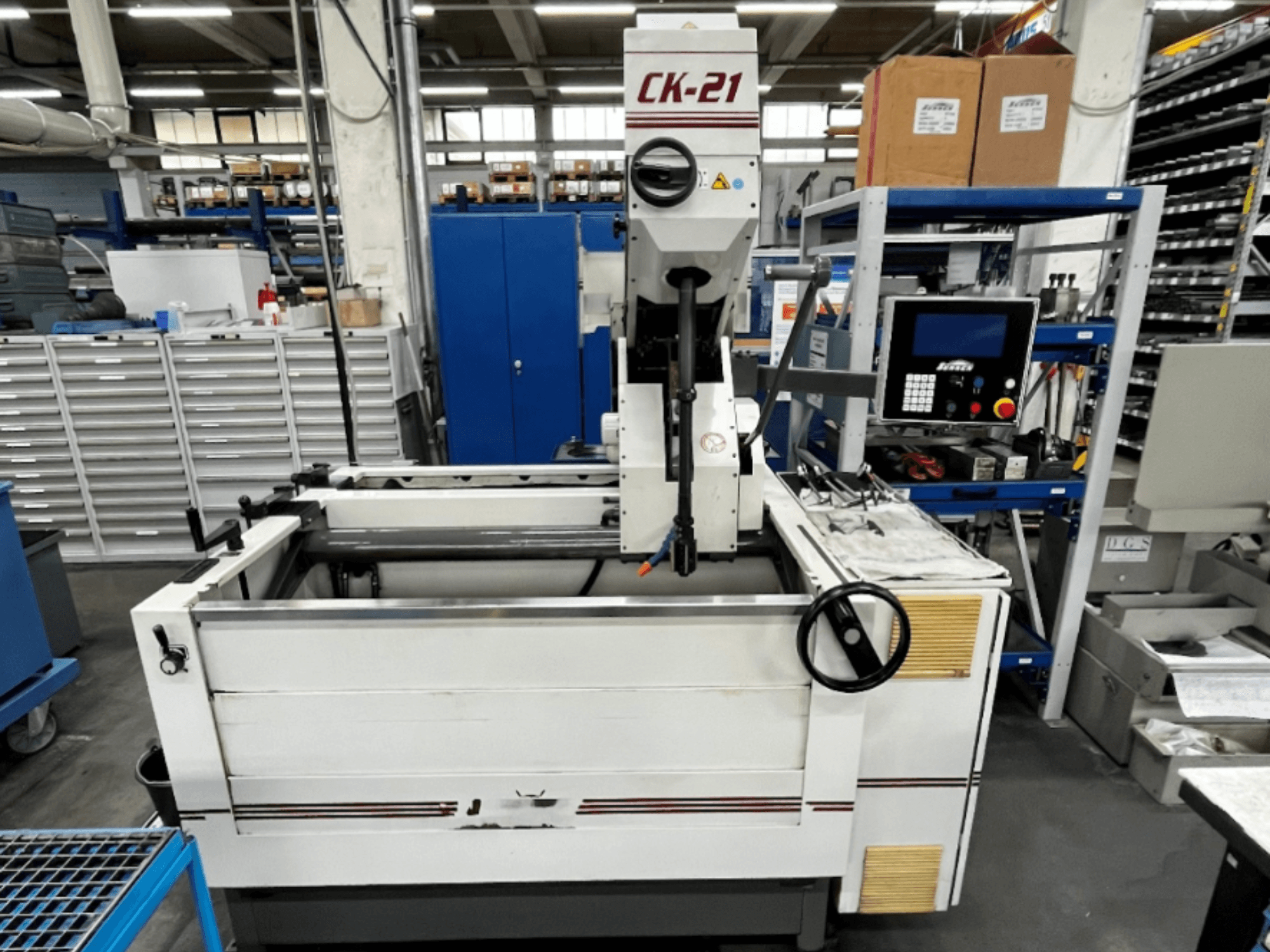 Vertikalna brusilica Sunnen CK-21-CC s prednje strane, s upravljačkim elementima, prostorom za brušenje i pratećom opremom u pozadini.