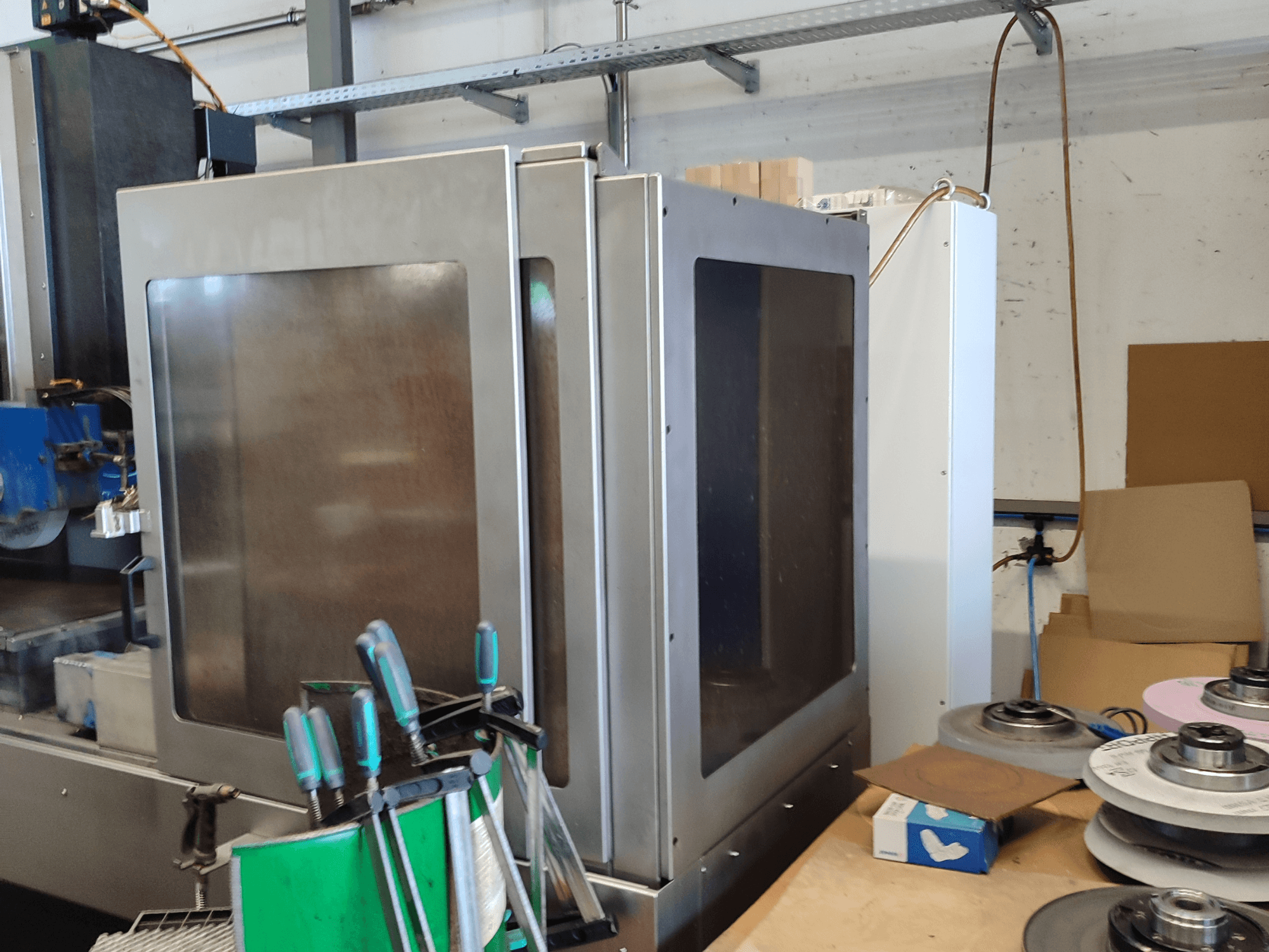 HEINZ STÖCKEL FD 1560 NC-T stroj za površinsko brušenje, bočni pogled koji prikazuje metalno kućište i komponente za brušenje u radioničkom okruženju.