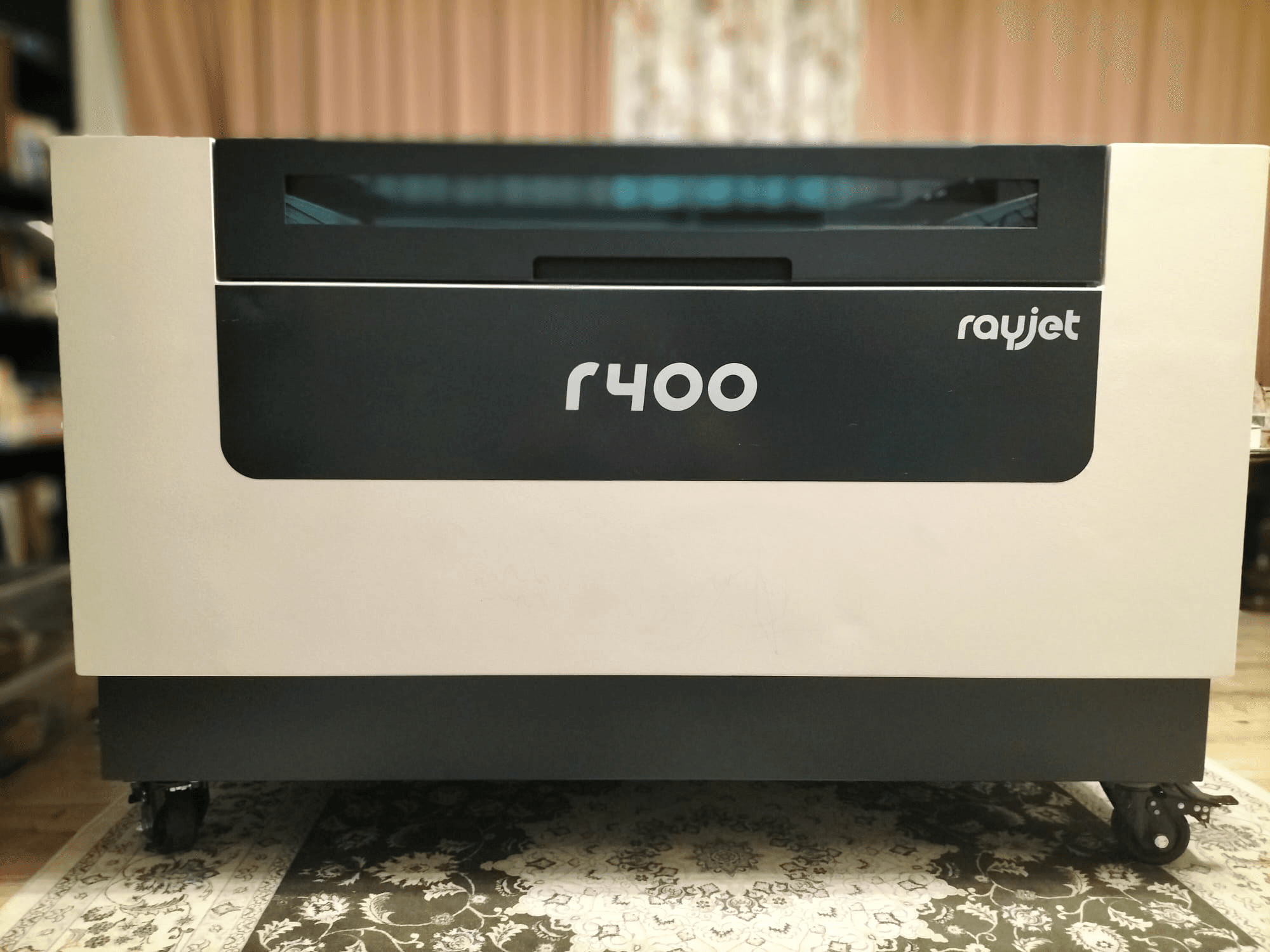 Prednji pogled na laserski gravirni stroj Trotec Rayjet R400, koji pokazuje njegov elegantan dizajn i jasan brending.