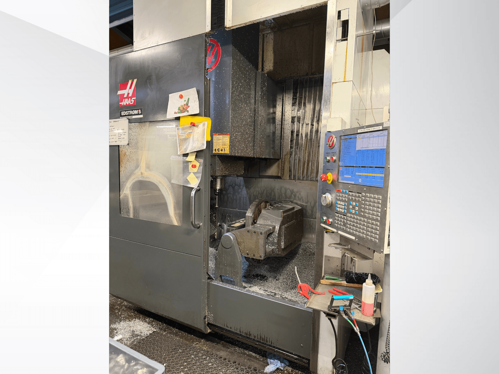 Haas CNC stroj model EDSTROM S, prednji pogled, prikazuje metalni obratak, upravljačku ploču i metalne strugotine unutra.