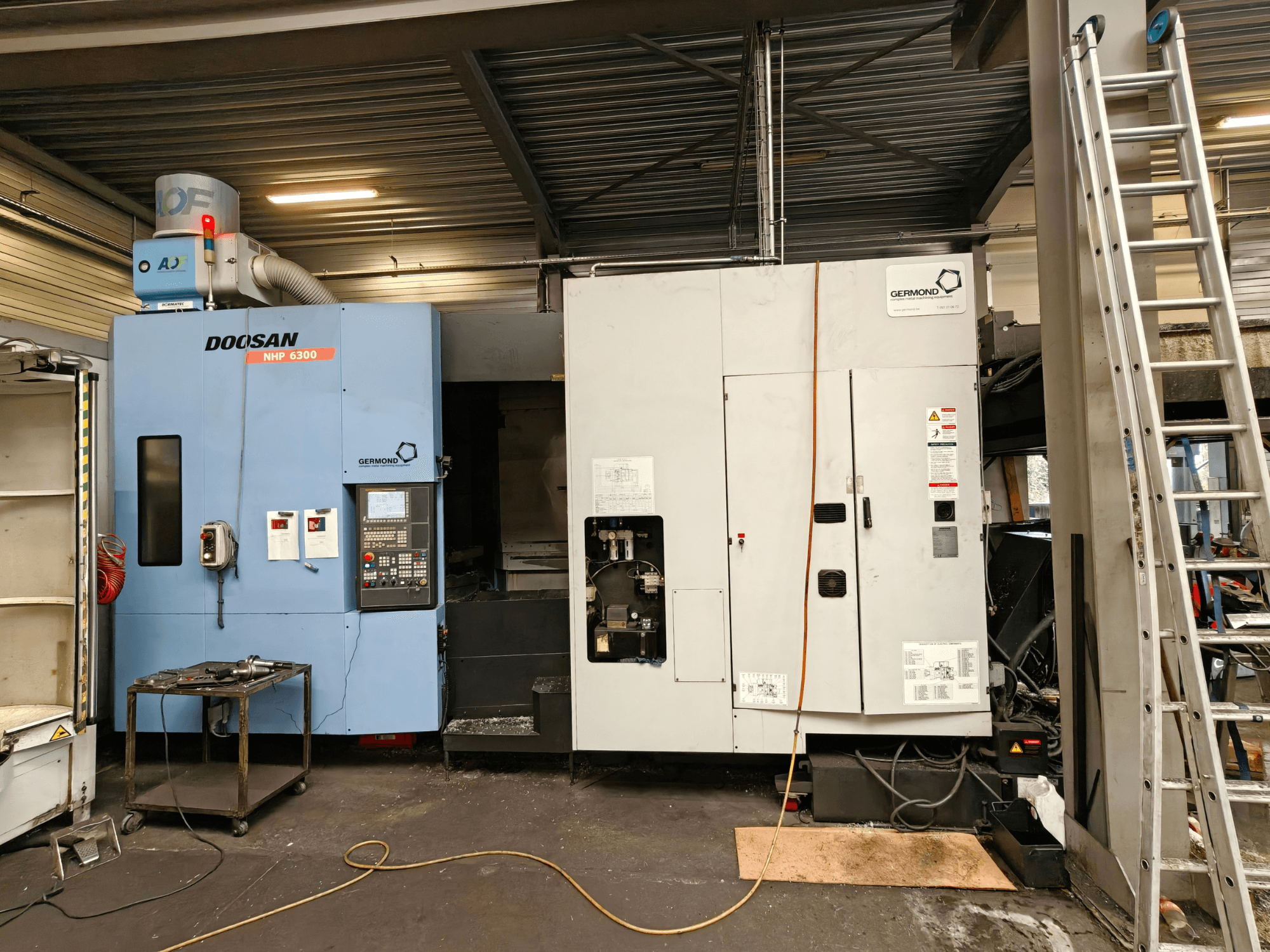 Horizontalni obradni centar DOOSAN NHP6300 u prednjem pogledu, s prikazom upravljačke ploče i susjednih strojeva u radioničkom okruženju.