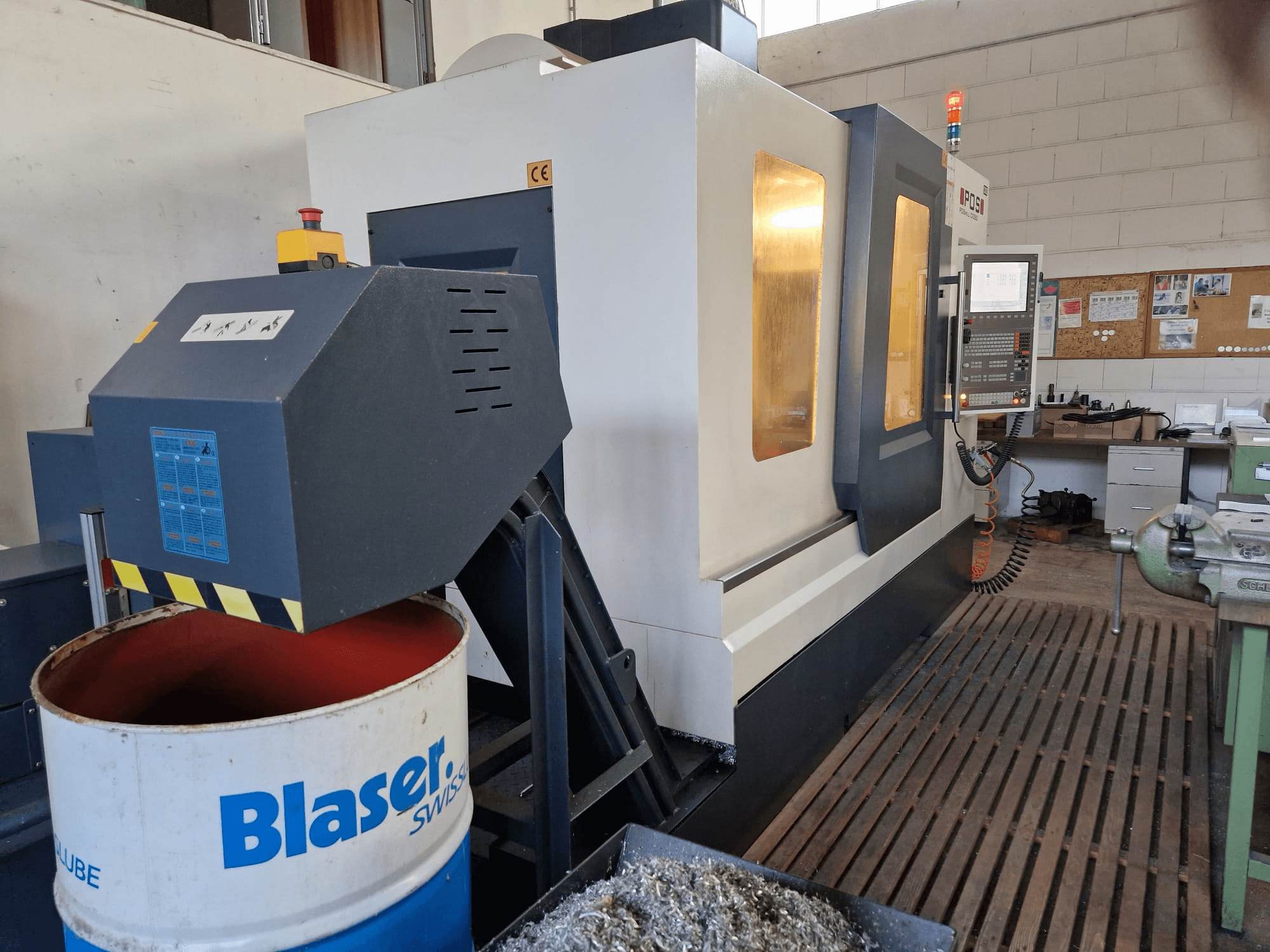 Prednji pogled na vertikalni obradni centar POSmill C 1050, s vidljivim sustavom hlađenja iznad Blaserovog bubnja i upravljačkom pločom.