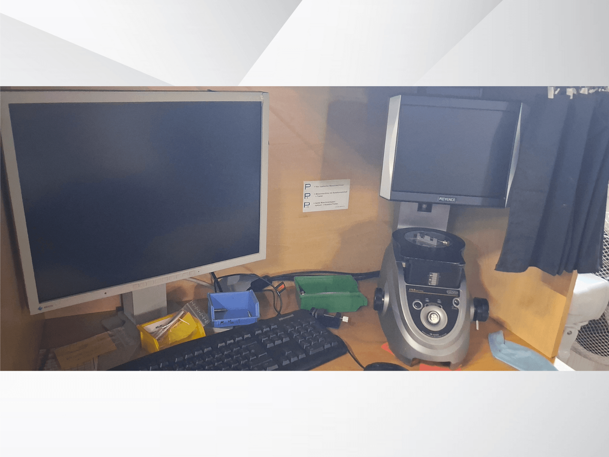 Računalni monitor s tipkovnicom, zaslonom marke PEVA i sivim laboratorijskim uređajem na drvenom stolu s raznim ladicama i papirima.