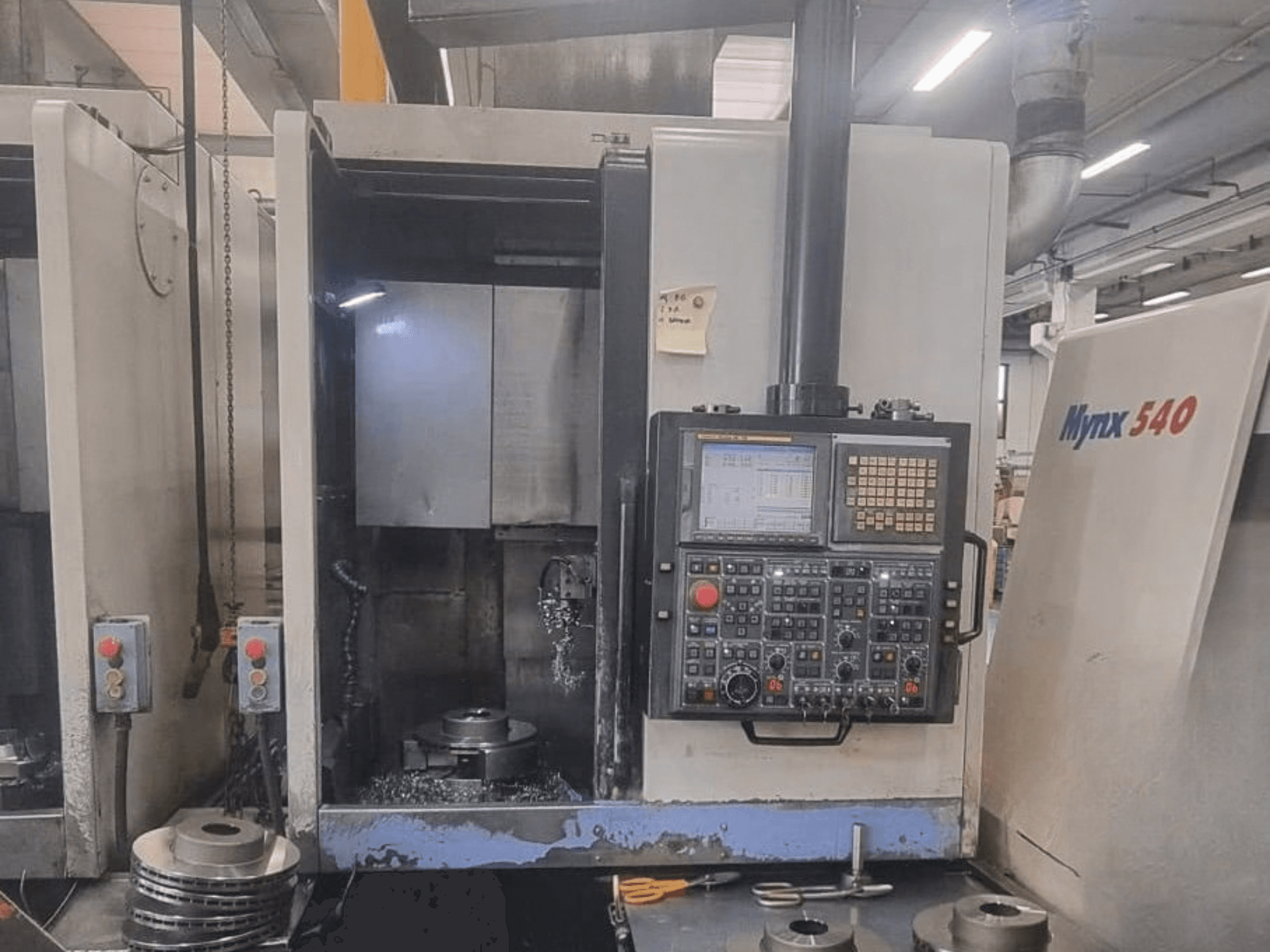 Prednji pogled na vertikalni tokarski stroj DOOSAN PUMA V400-2SP, s prikazom upravljačke ploče i postavki obratka unutar stroja.