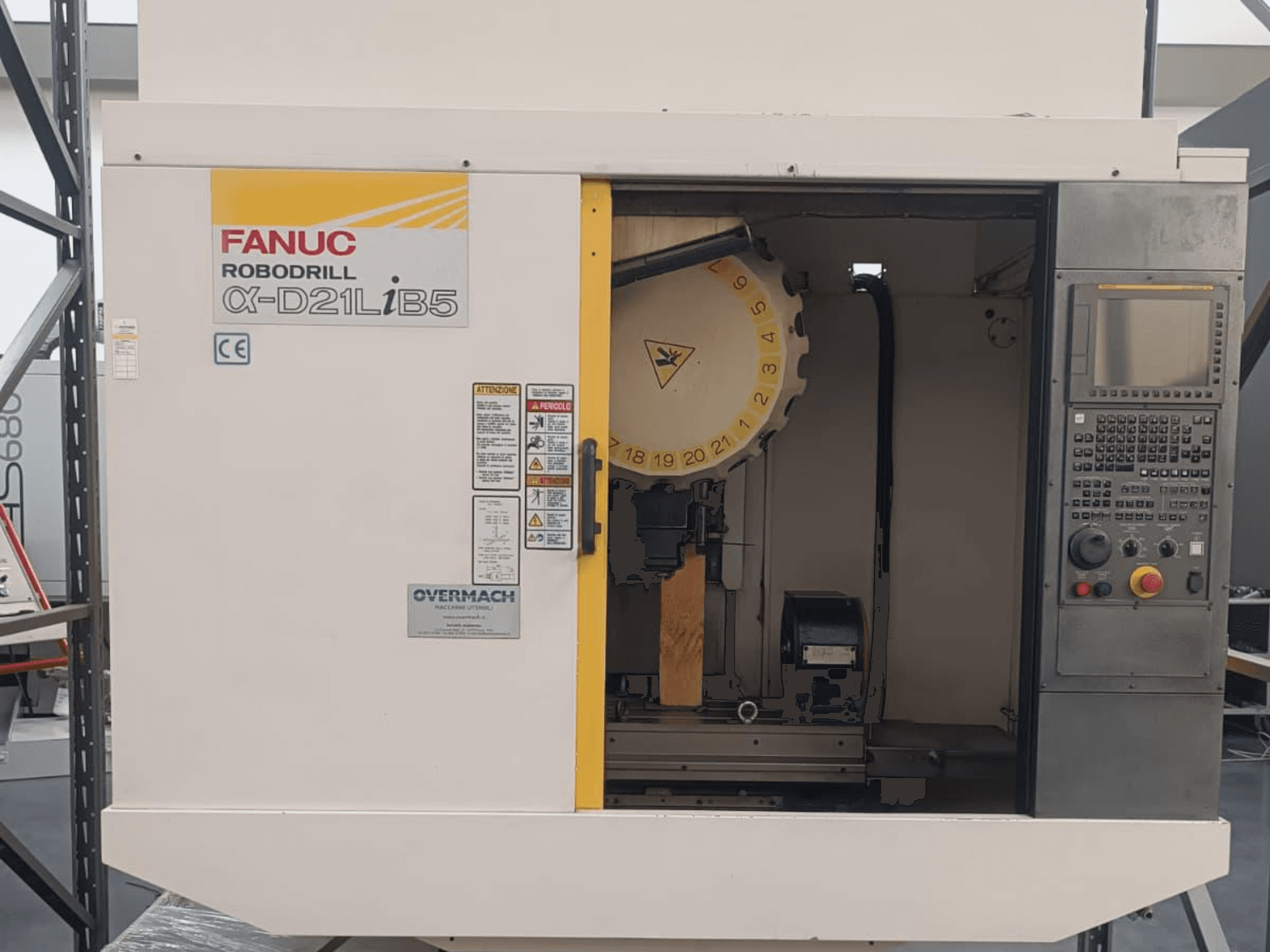 FANUC Robodrill α-D21LiB5, pogled sprijeda; CNC stroj s držačem alata, upravljačkom pločom i vidljivim sigurnosnim upozorenjima.