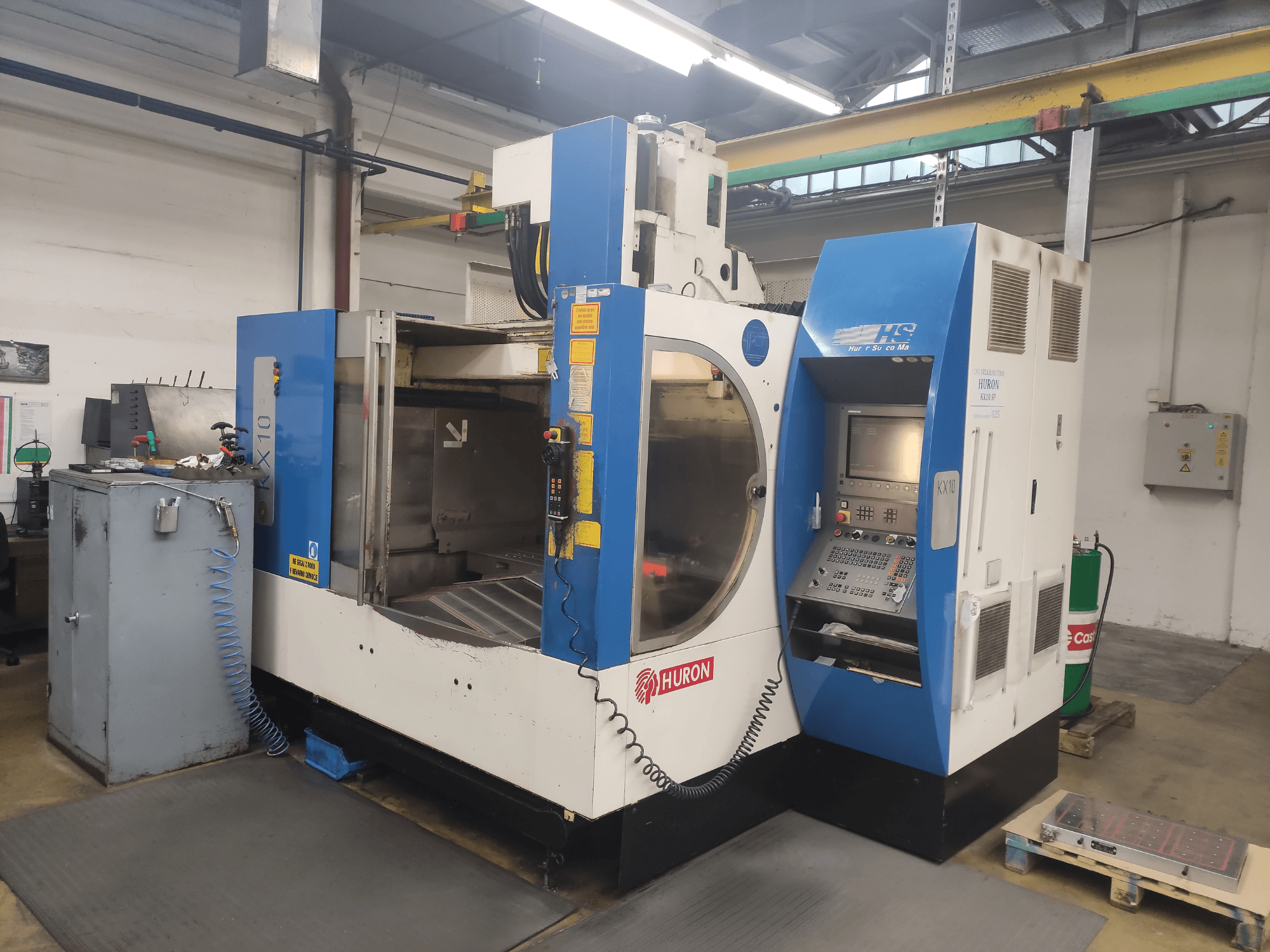 HURON KX10 CNC stroj u radionici, prednji pogled, s upravljačkom pločom i velikim otvorom za obradu.