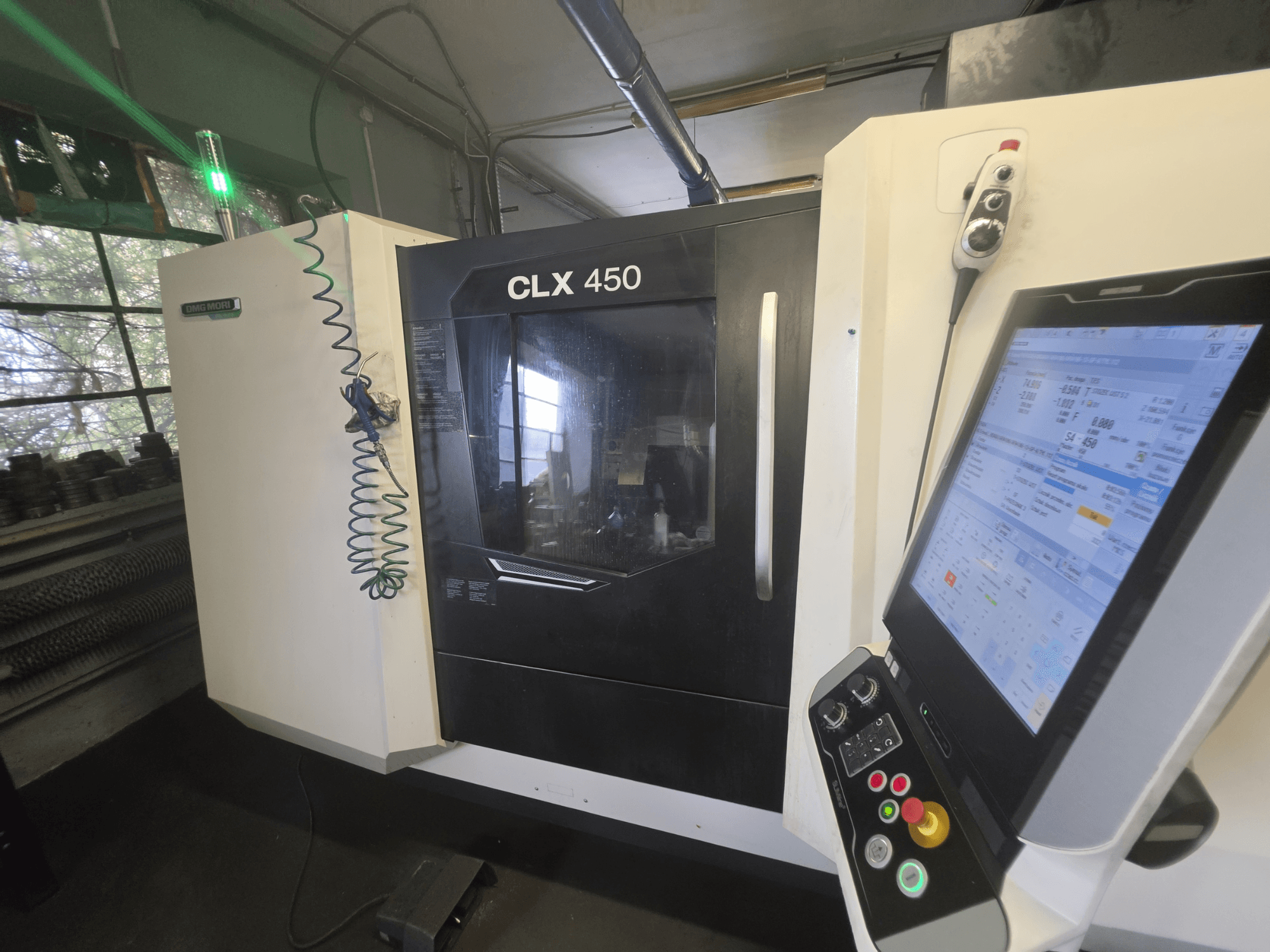 DMG MORI CLX 450 V3 horizontalni tokarski stroj, prednji pogled s upravljačkom pločom i monitorom koji prikazuje radne podatke.