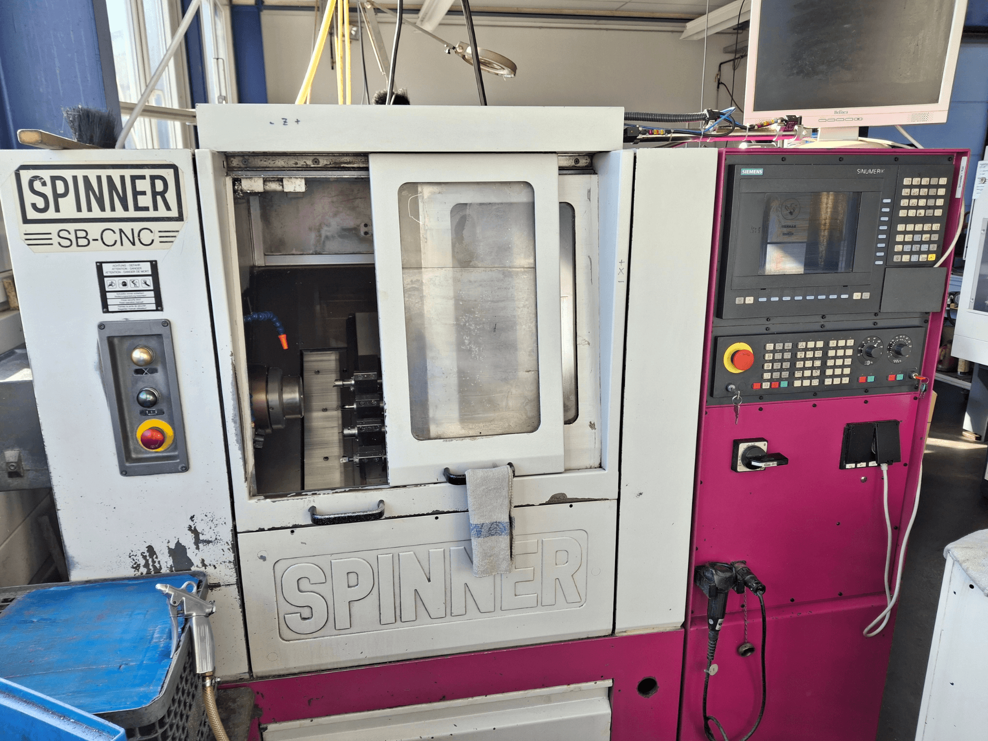 Horizontalni tokarski stroj SPINNER SB-CNC, prednji pogled s upravljačkom pločom, držačem alata i indikatorima rada.
