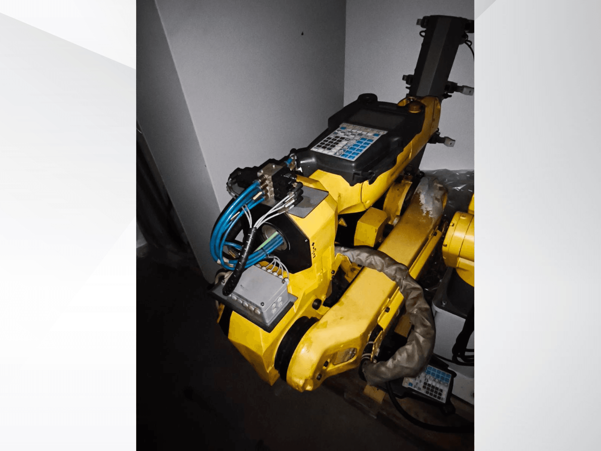 Bočni pogled na robotsku ruku FANUC M-20iA, koja prikazuje žuto tijelo, upravljačku ploču i spojeno ožičenje.