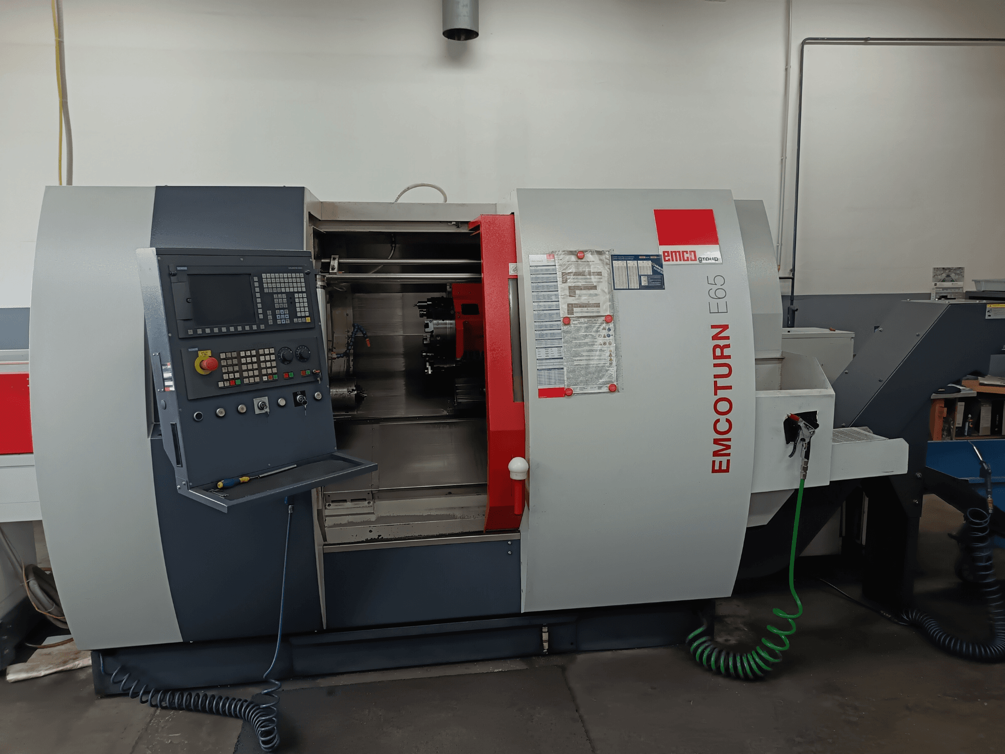 EMCO EMCOTURN E65 tokarsko-glodački centar, prednji pogled s upravljačkom pločom, unutarnjim mehanizmom i značajkama u radioničkom okruženju.