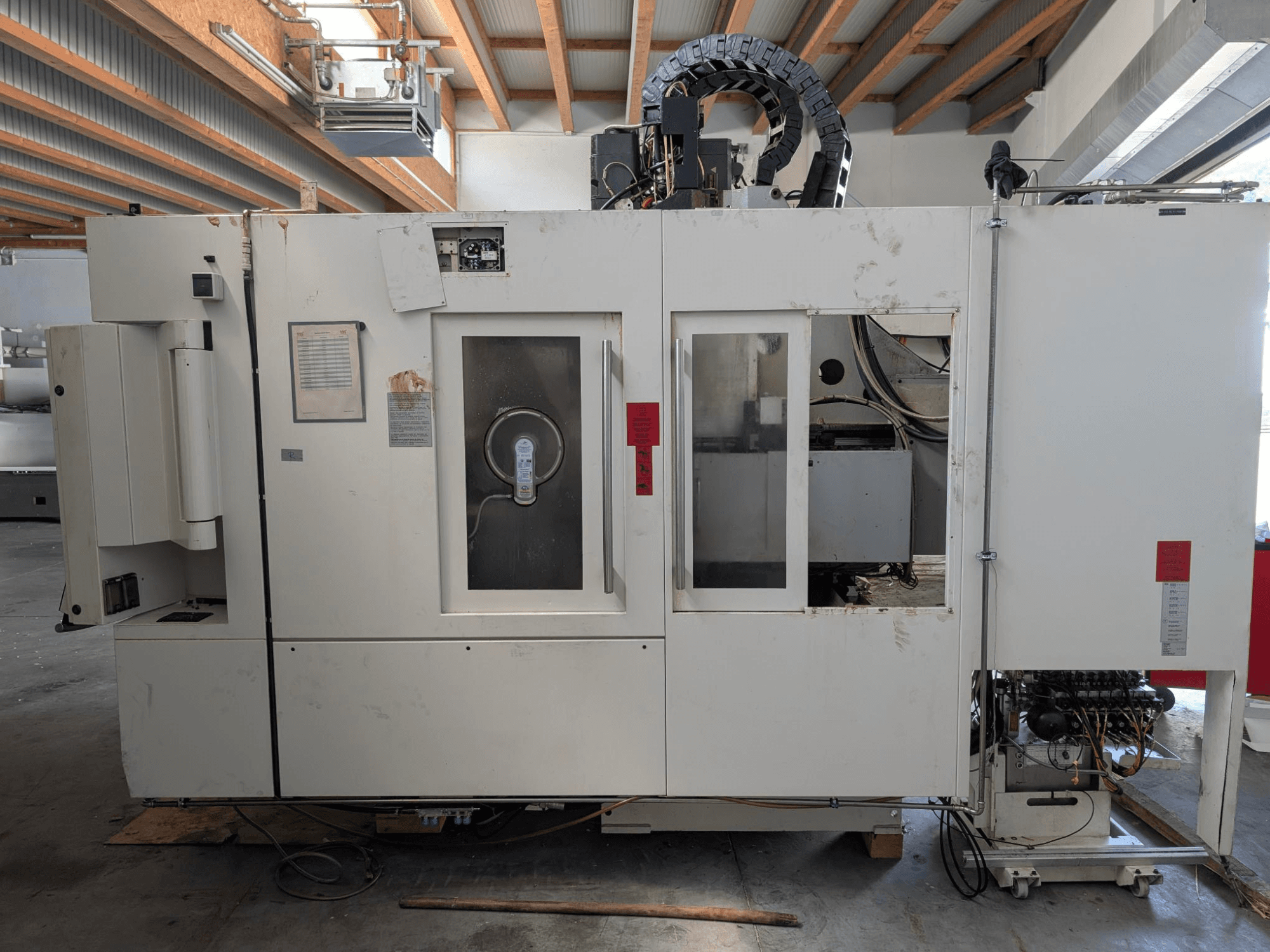 Vertikalni obradni centar STAMA MC 326, bočni pogled koji prikazuje upravljačku ploču, područje vretena i razne oznake na stroju.