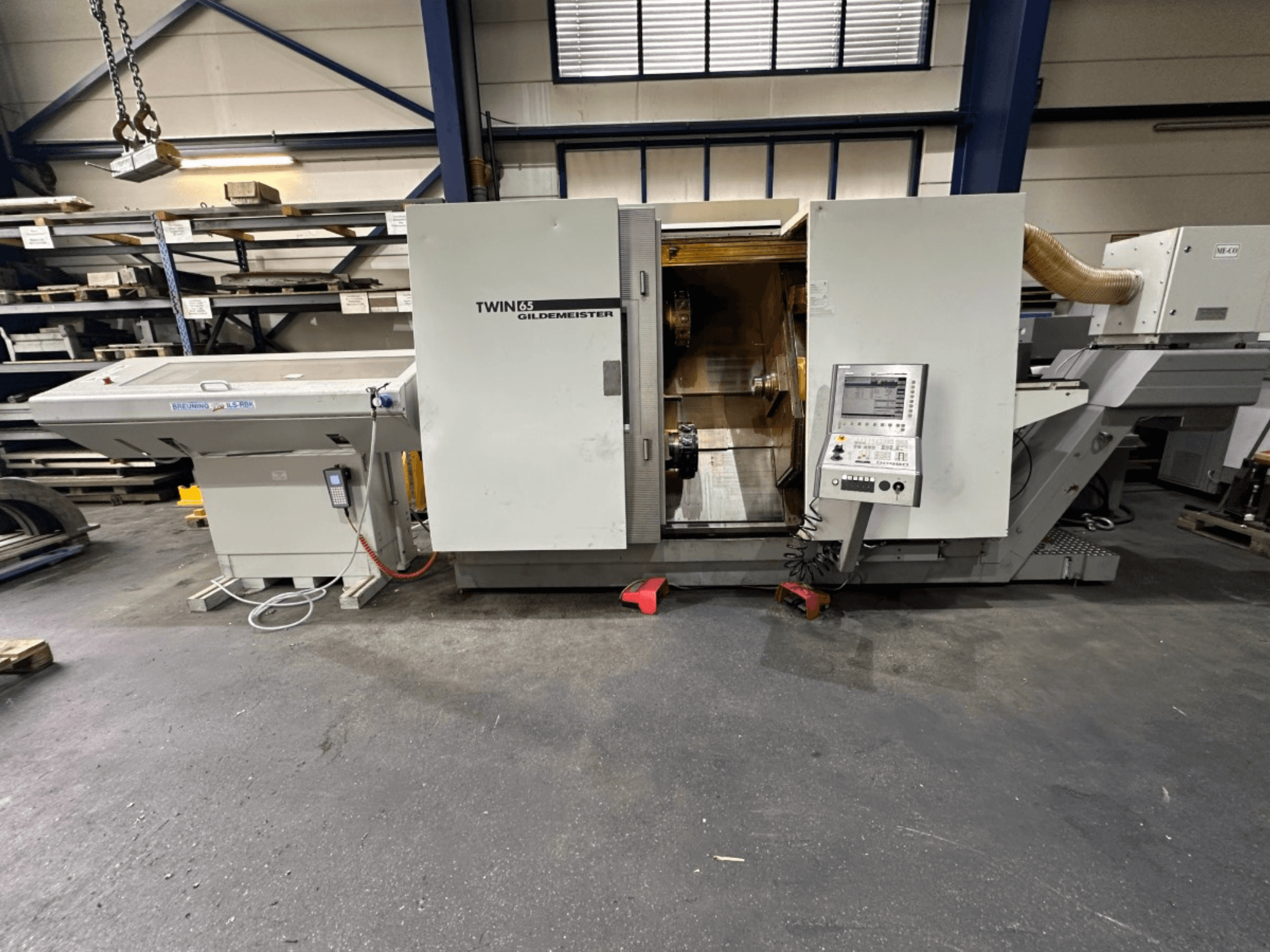 Gildemeister TWIN 65 horizontalni tokarski stroj, pogled sprijeda; ima upravljačku ploču i vidljivu unutrašnjost za obradu dijelova.