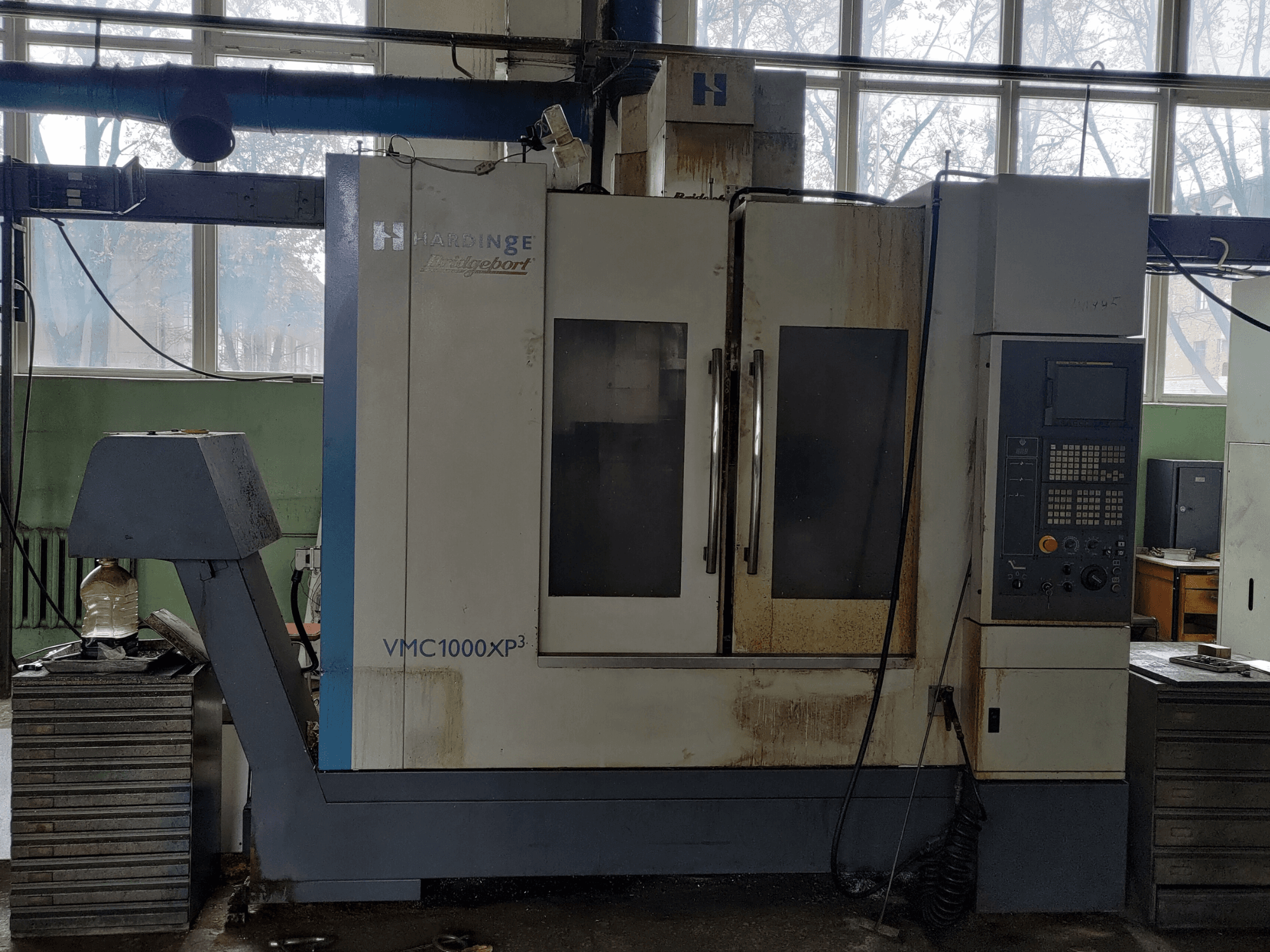 Vertikalni obradni centar Bridgeport VMC1000 XP3 u prednjem pogledu, s prikazom upravljačke ploče i blagog istrošenosti.