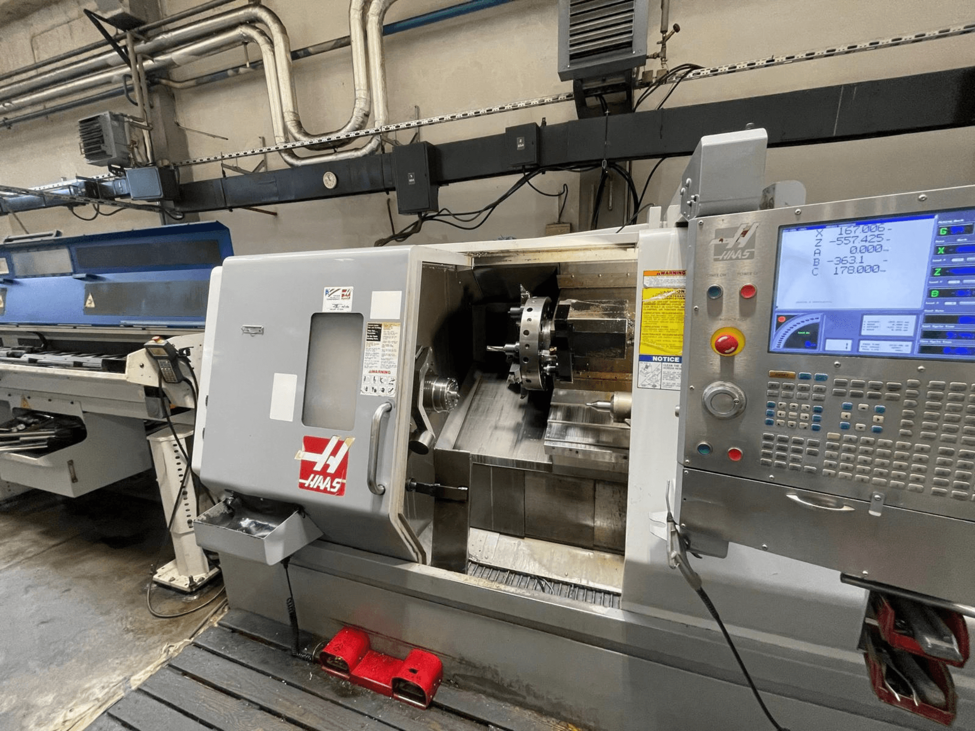 Haas SL-30THE horizontalni tokarski stroj u radionici s digitalnom upravljačkom pločom i izloženim radnim prostorom.