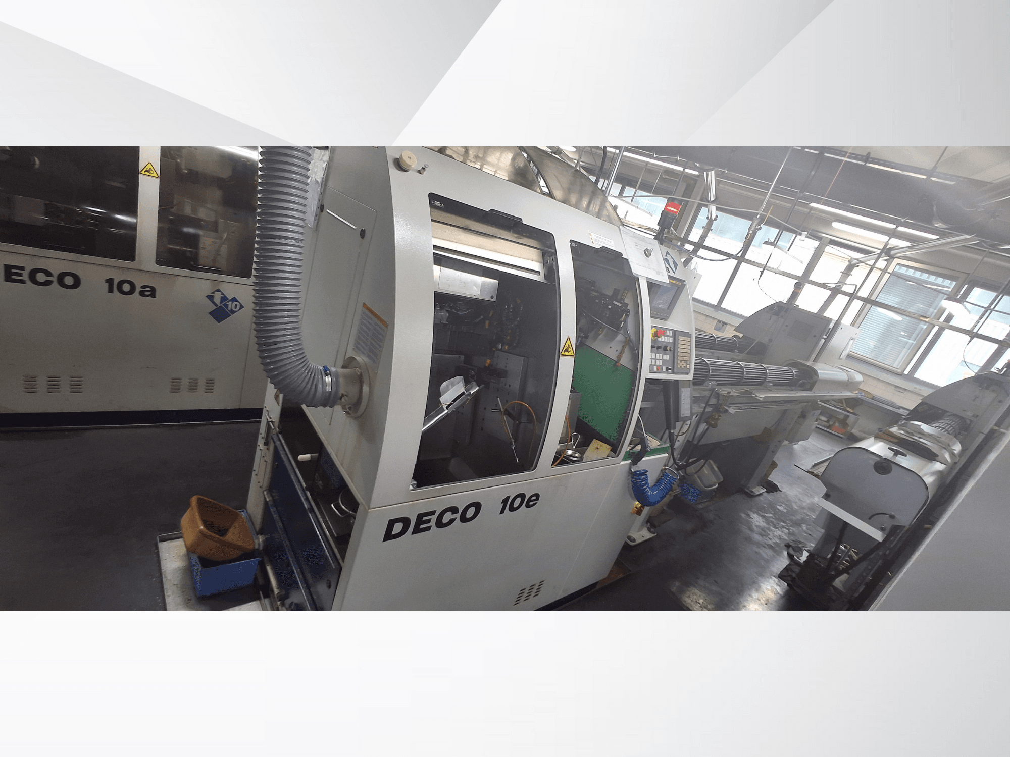 DECO 10e CNC stroj u bočnom pogledu, s upravljačkom pločom, zelenom unutrašnjosti i spojenim ispušnim crijevom.