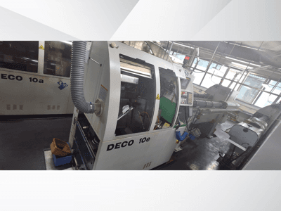 DECO 10e CNC stroj u bočnom pogledu, s upravljačkom pločom, zelenom unutrašnjosti i spojenim ispušnim crijevom.