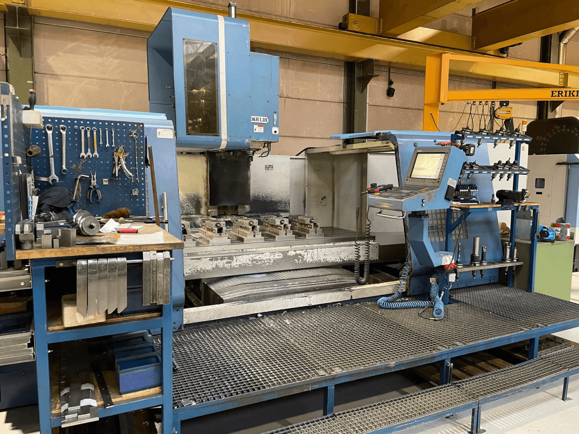 Prednji pogled na vertikalni obradni centar DAH LIH MCV2600, s prikazom upravljačke ploče, radnog stola i prostora za pohranu alata.