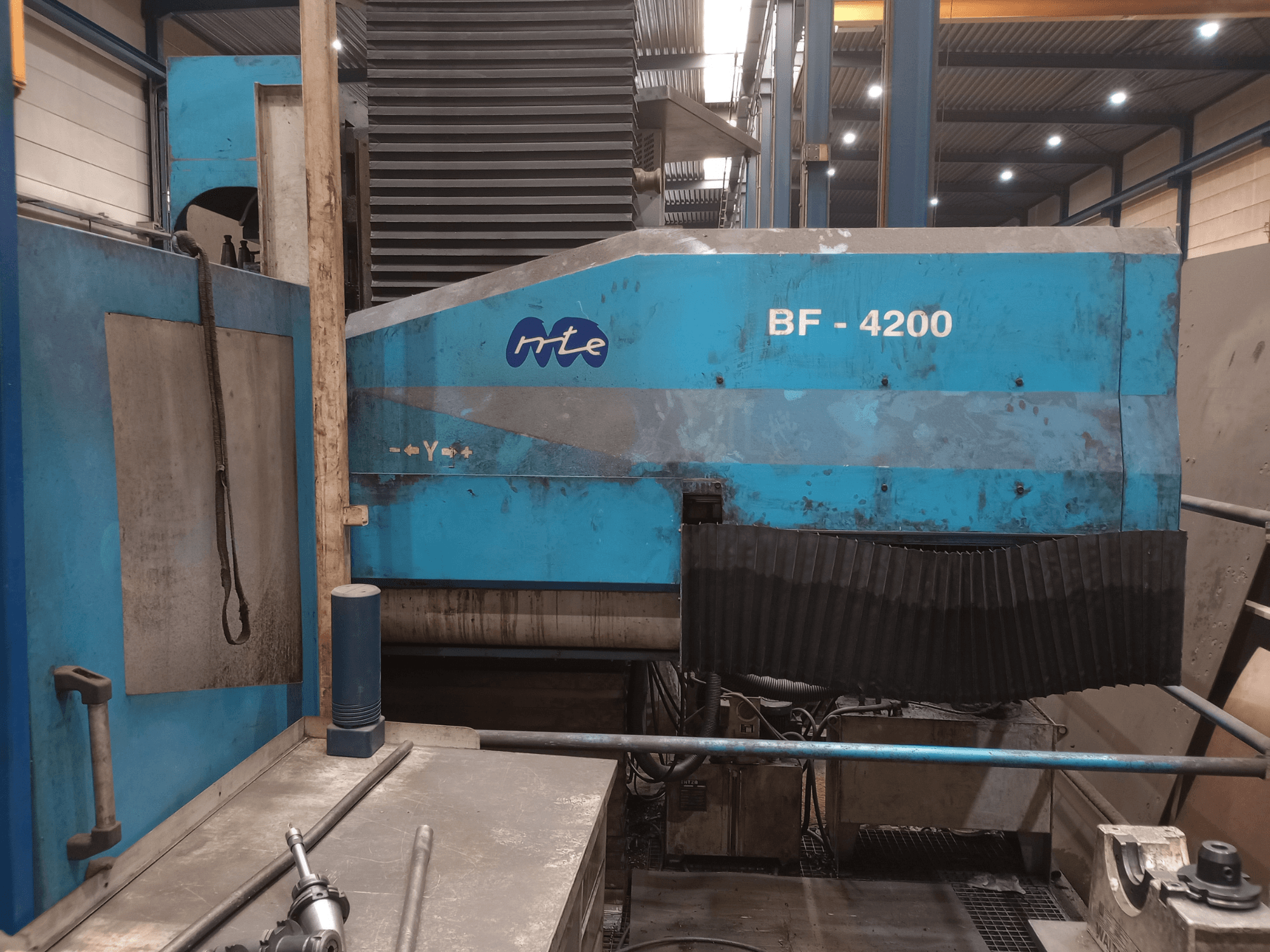 Glodalica s krevetom MTE BF 4200, bočni pogled, prikazuje plavu vanjštinu i detaljne komponente stroja u radioničkom okruženju.