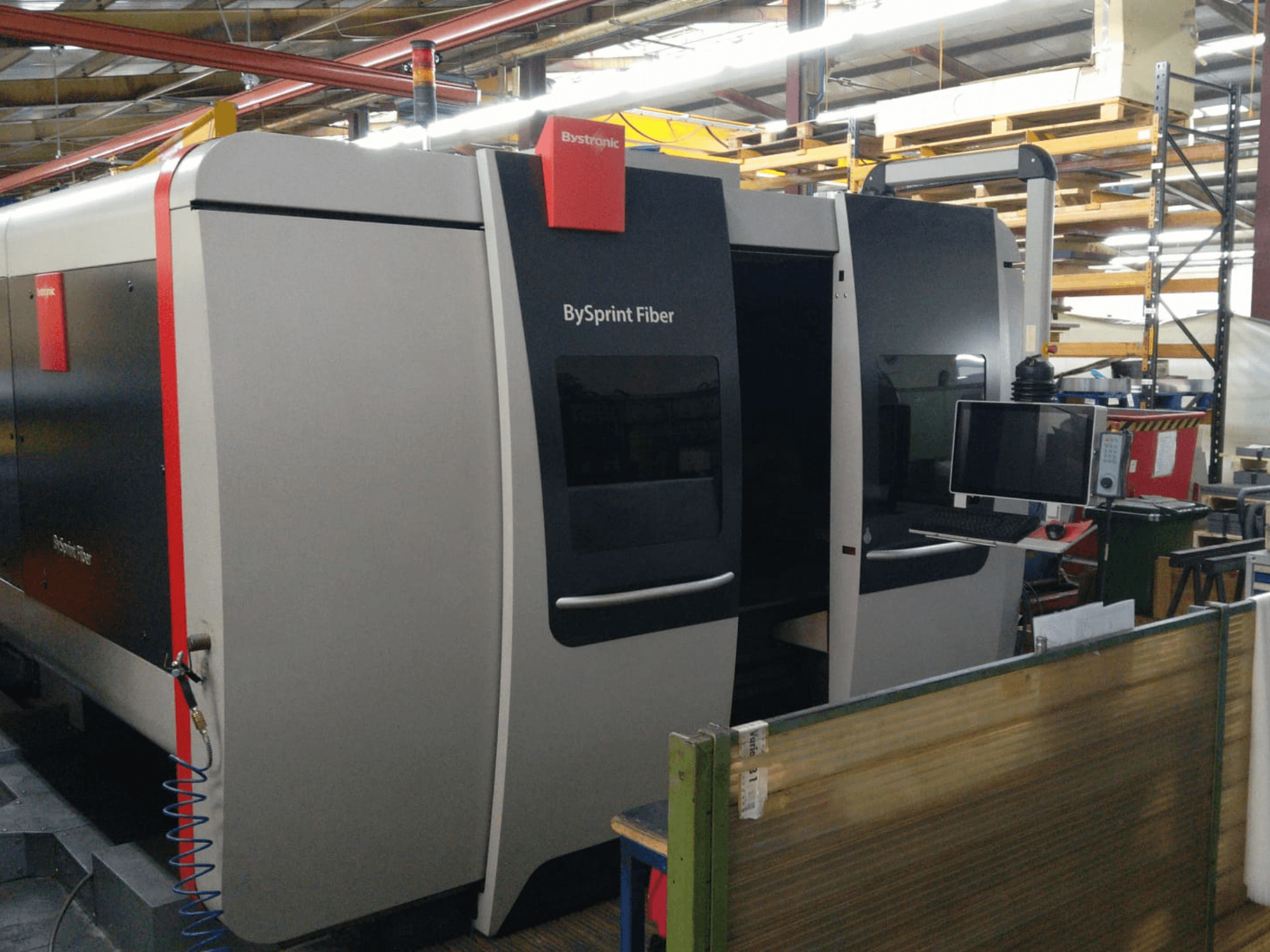 Bystronic BySprint Fiber laserski rezač, prednji pogled s upravljačkom pločom, vidljivi detalji uključuju dvoja vrata i monitor sa strane.