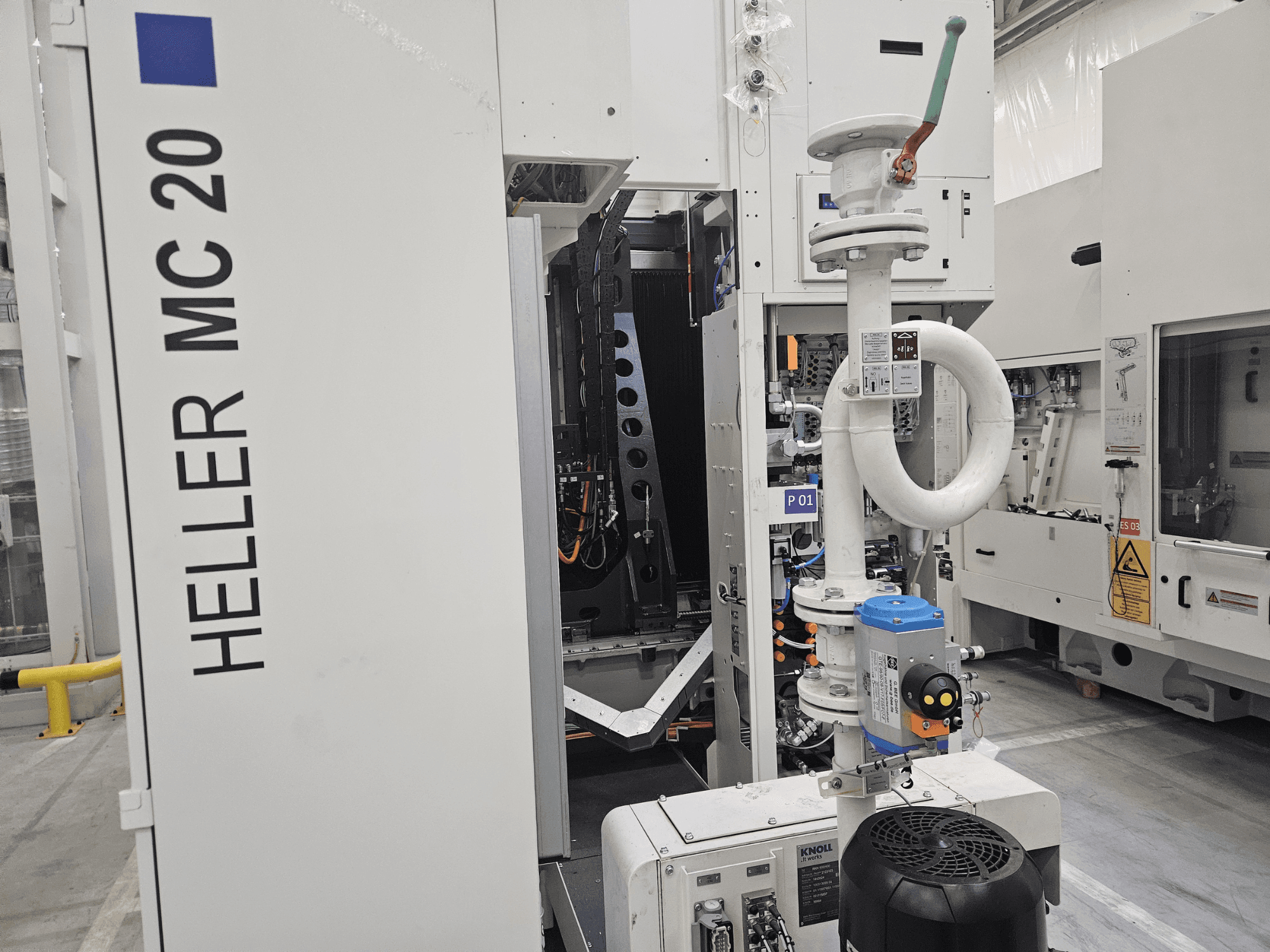 Stroj Heller MC 20 u tvorničkom okruženju, s bočnom slikom upravljačke ploče i mehaničkih komponenti.