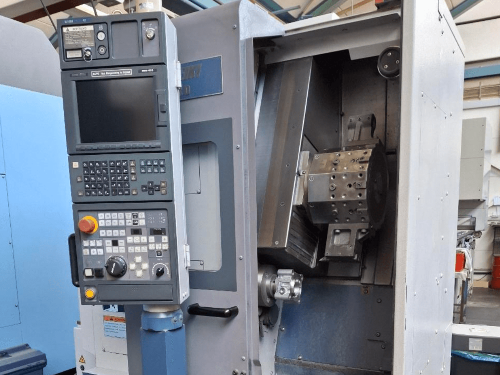 Prednji pogled na horizontalni tokarski stroj MORI SEIKI SL 1000, s upravljačkom pločom i detaljnim unutarnjim mehanizmom.