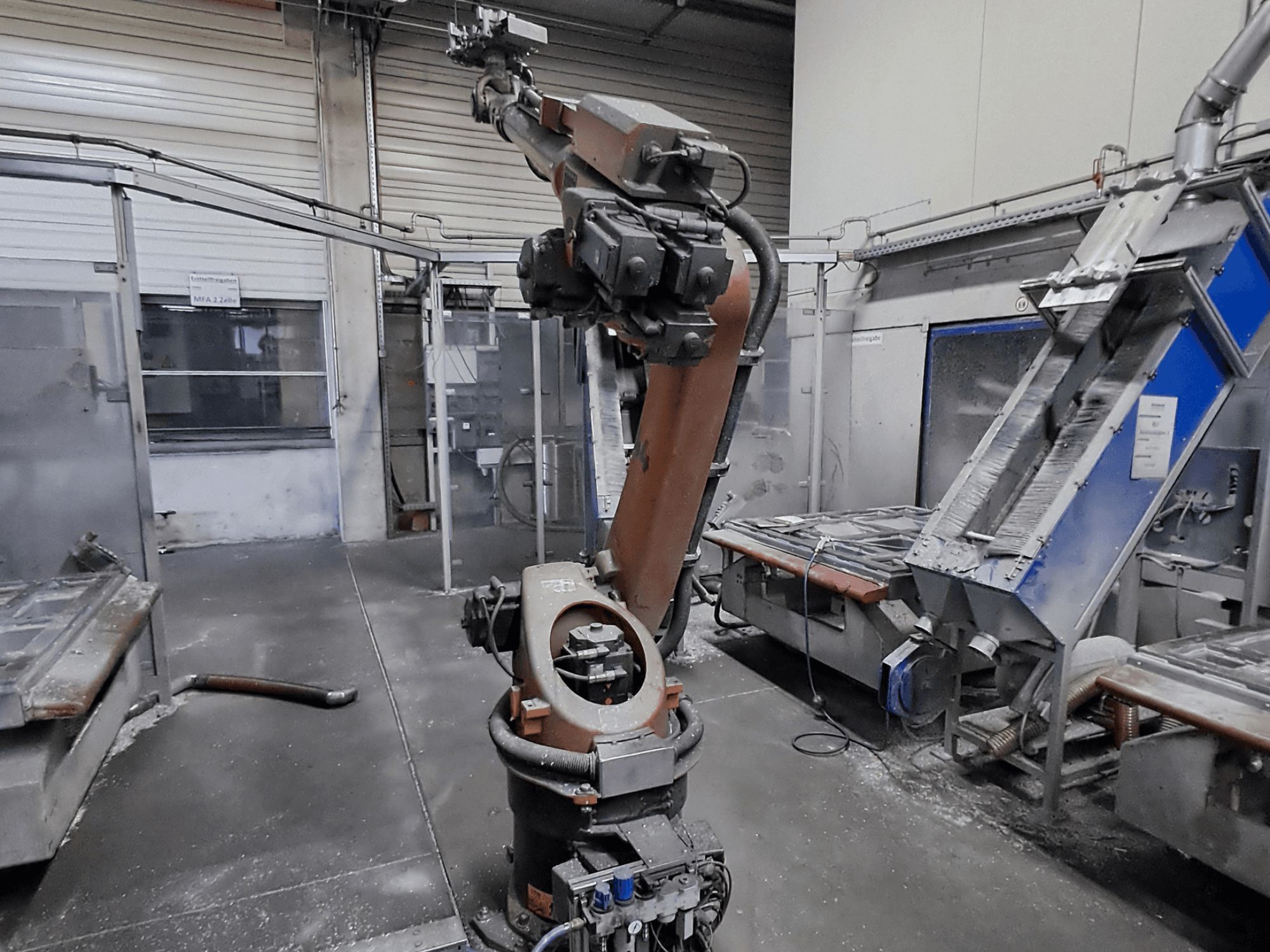 Robotska ruka KUKA KR 30L16-2 u radioničkom okruženju, prednji pogled, s vidljivom prašinom i strojevima u pozadini.