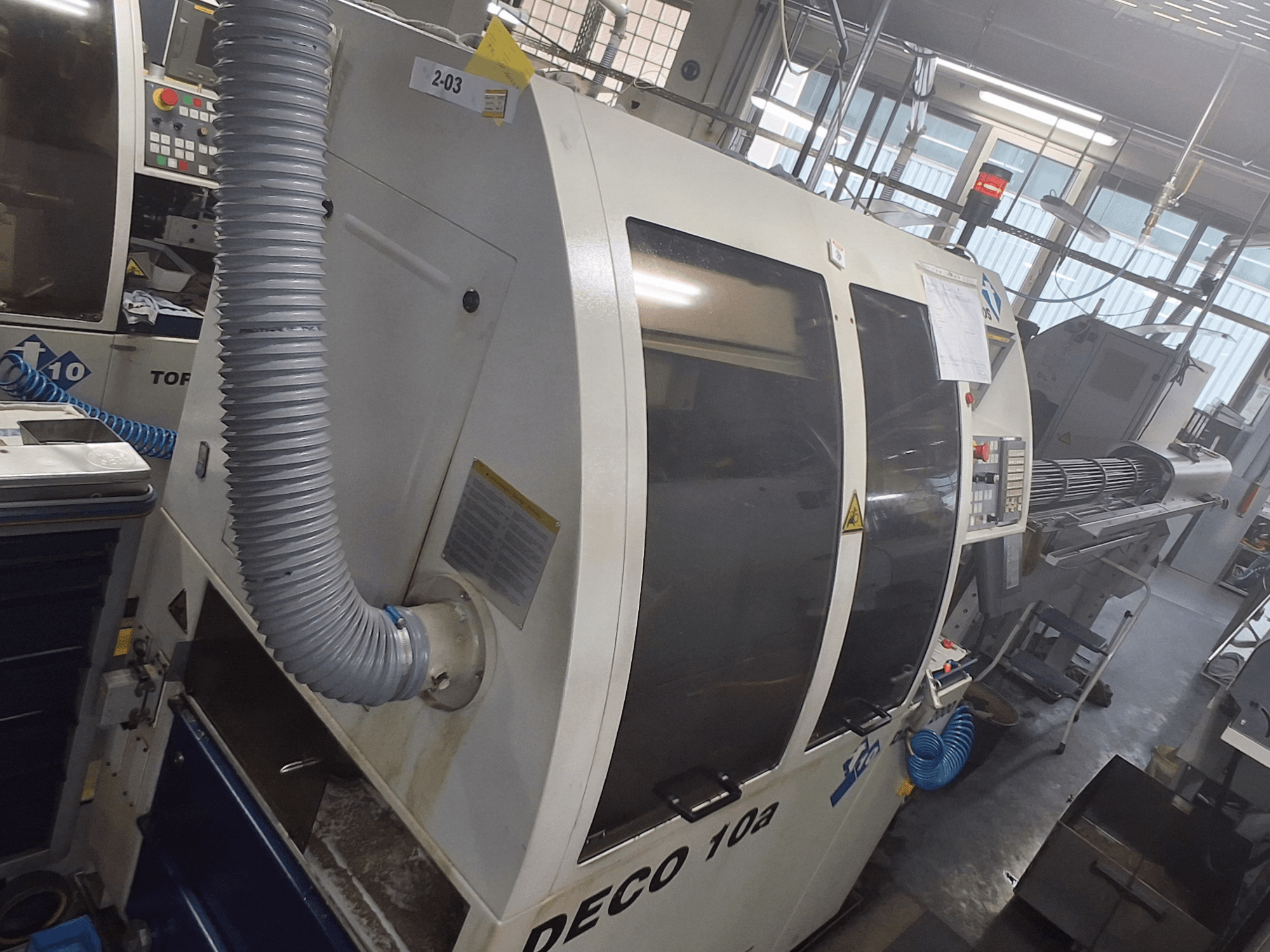 DECO 10a stroj u prednjem pogledu; ima veliku upravljačku ploču, kanale i vidljive naljepnice s uputama za uporabu.