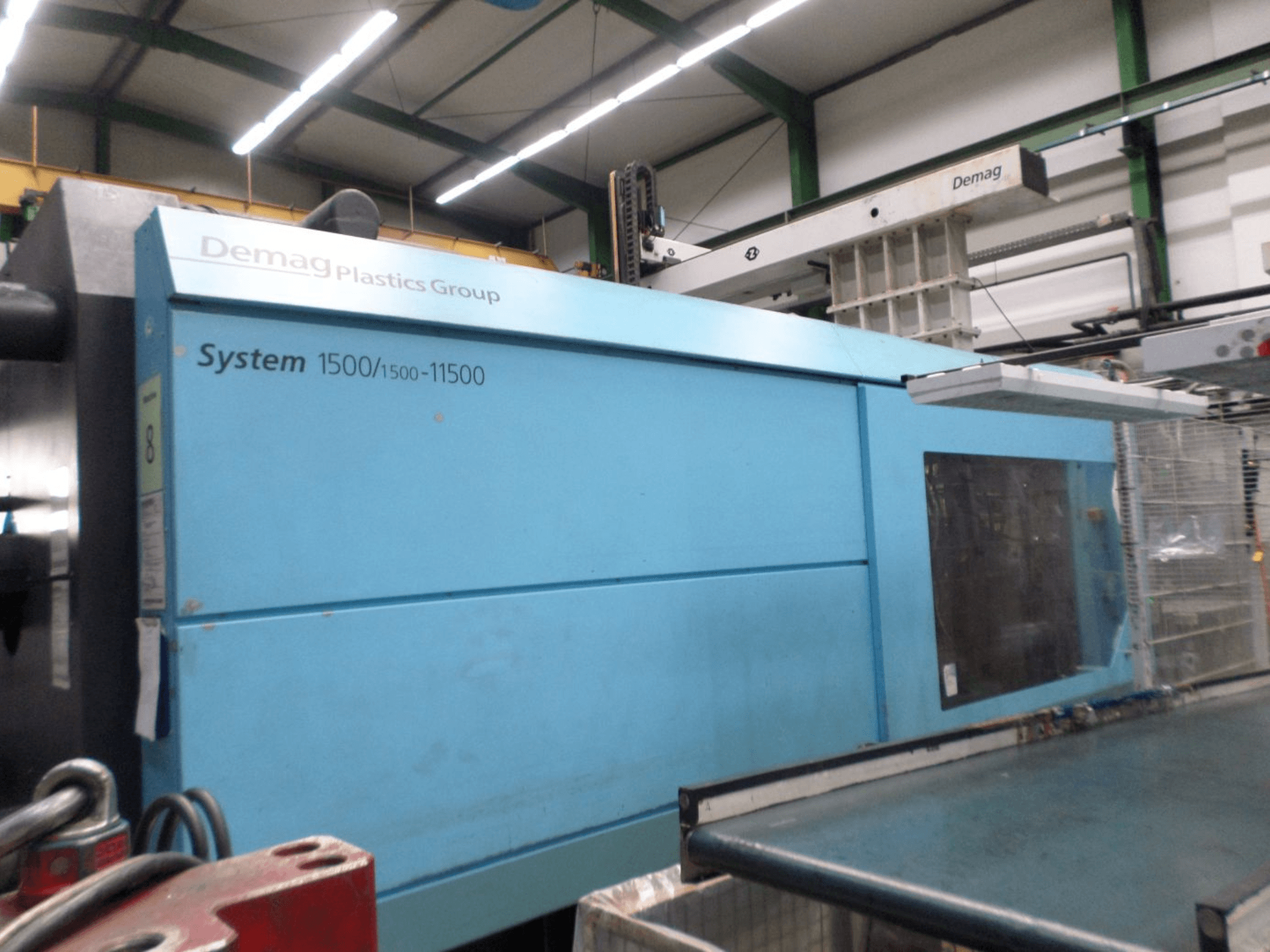Demag D 650 hidraulički stroj za brizganje plastike u plavoj boji, bočni pogled s oznakom i radnim područjem System 1500/1500-11500.