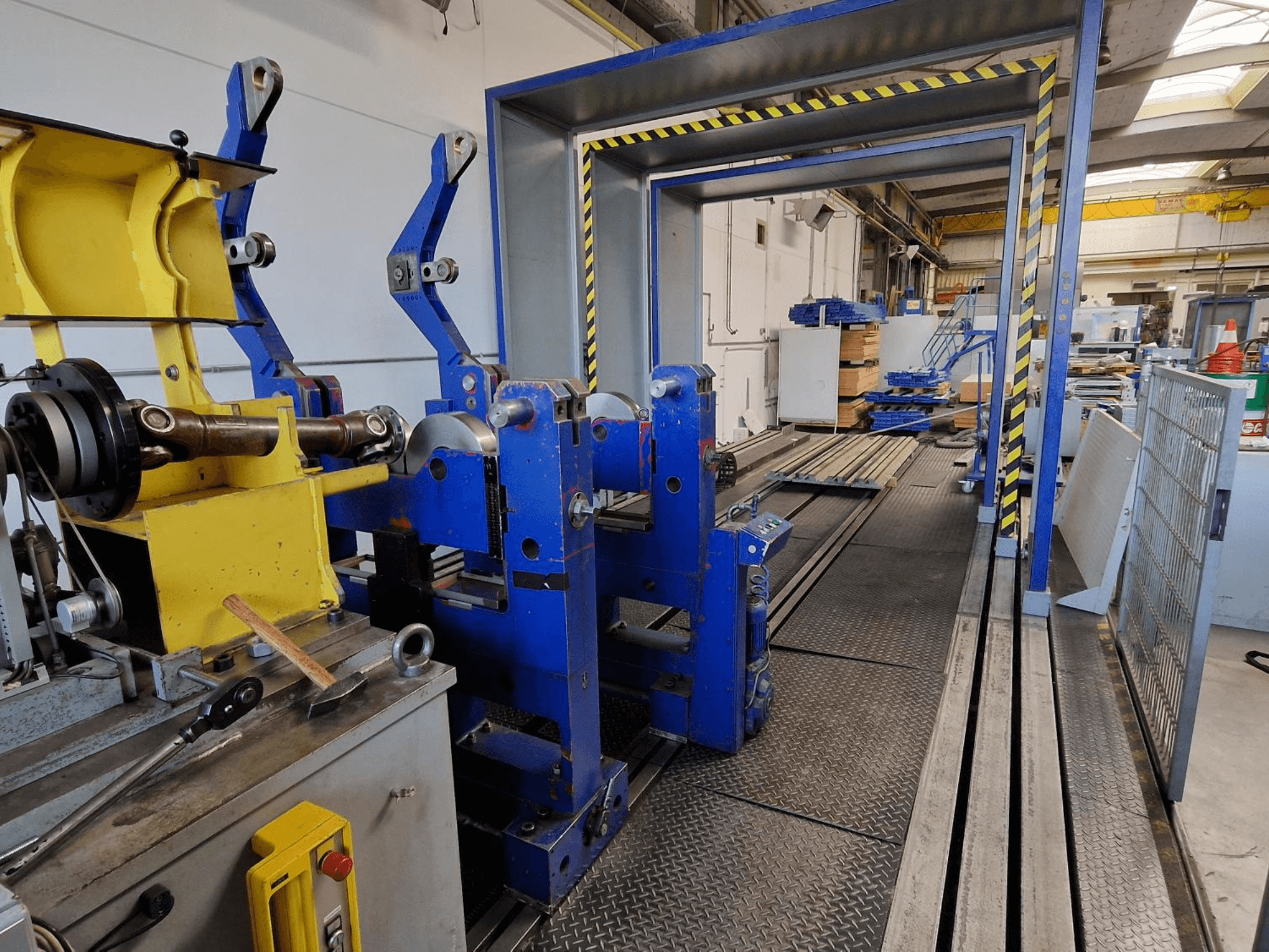 SCHENCK HM 70U BU alatni stroj, bočni pogled koji prikazuje plavu strukturu sa žutim komponentama i upravljačkom pločom u industrijskom okruženju.