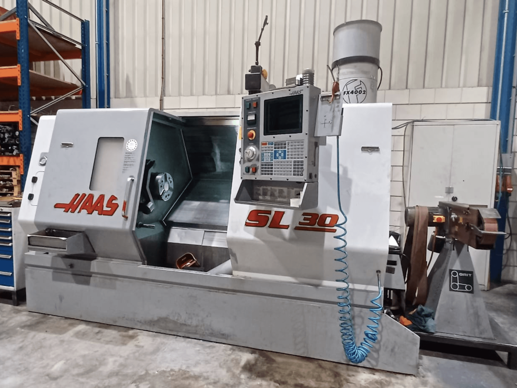 Bočni pogled na Haas SL 30 CNC tokarilicu, s prikazom upravljačke ploče, područja obrade i integriranog sustava hlađenja za obradu metala.