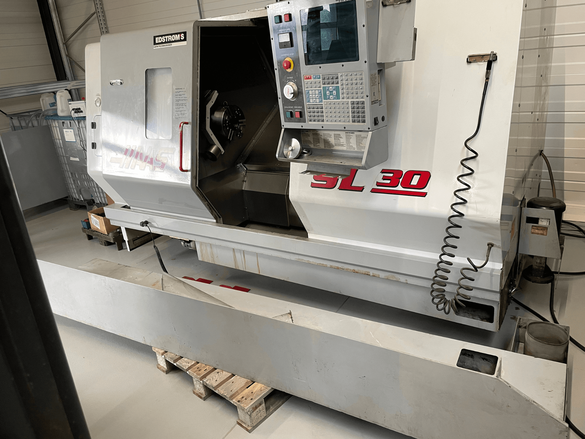 Haas SL 30 CNC tokarski stroj u radionici, bočni pogled, s upravljačkom pločom i otvorenim vretenom za strojnu obradu.