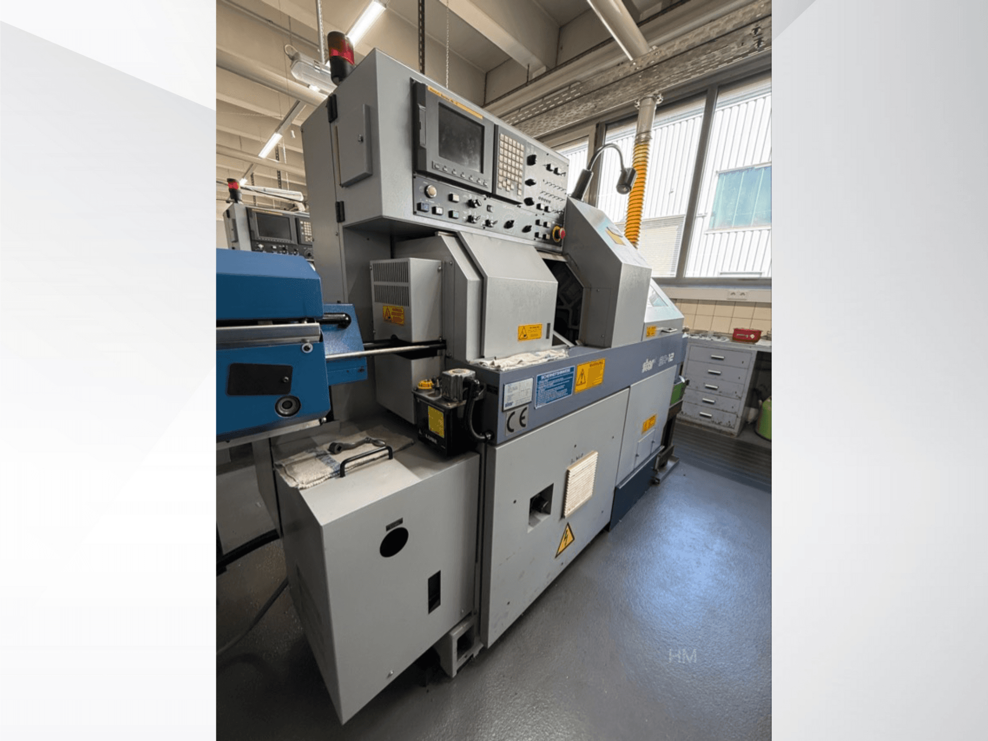 Prednji pogled na stroj Lithec 3231, s prikazom upravljačke ploče, motora i plavog dijela za uvlačenje u dobro osvijetljenom industrijskom okruženju.