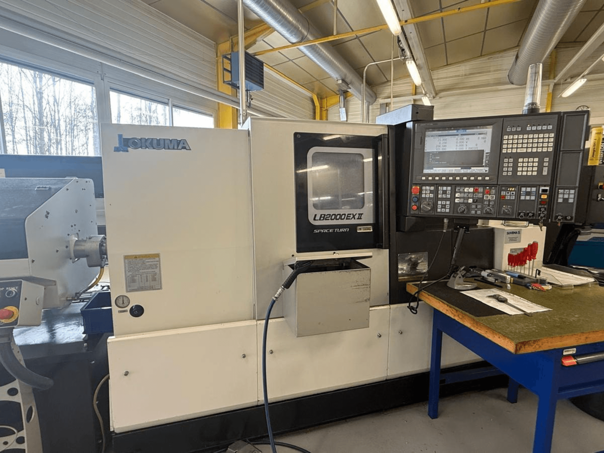 Okuma LB2000EX II horizontalni tokarski stroj, pogled sprijeda; sadrži upravljačku ploču, područje vretena i okolni radni prostor.