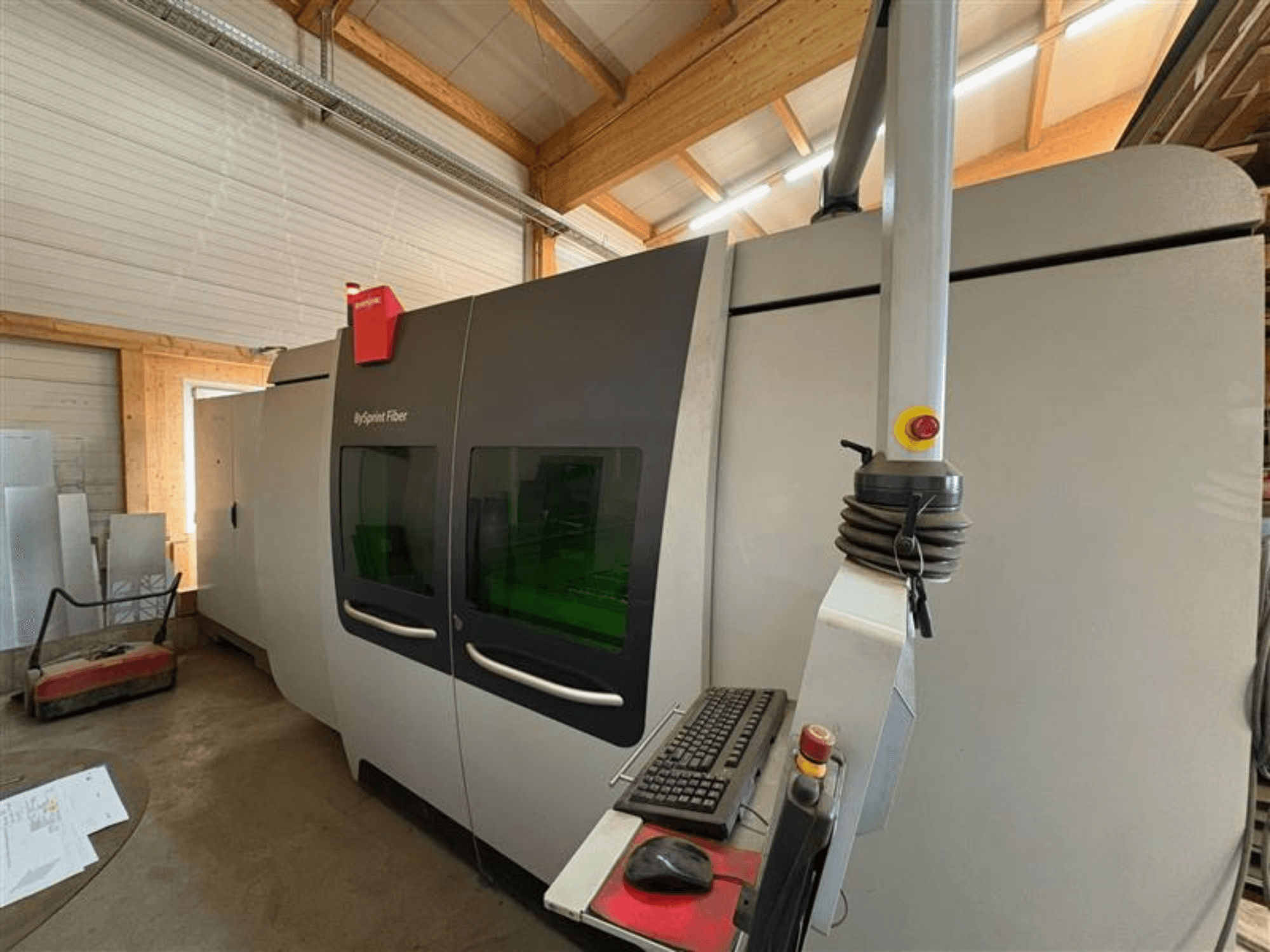 Stroj za rezanje vlakana Bystronic ByJet u radionici, prednji pogled s upravljačkom pločom i dvostrukim zelenim prozorčićima za pregled.