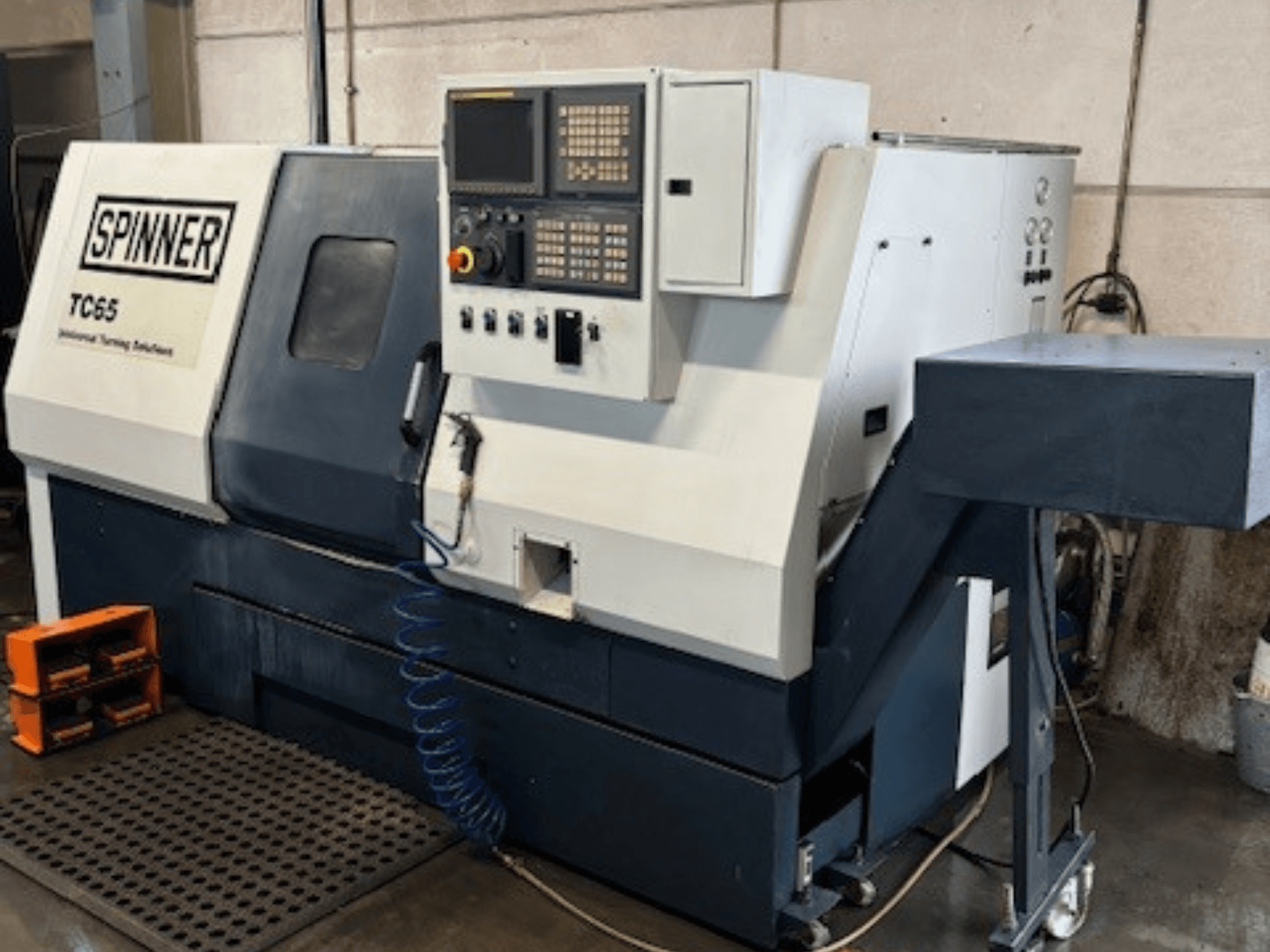 Industrijski tokarski stroj Spinner TC65, prednji pogled, sadrži upravljačku ploču, vod za komprimirani zrak i prostor za pohranu alata.