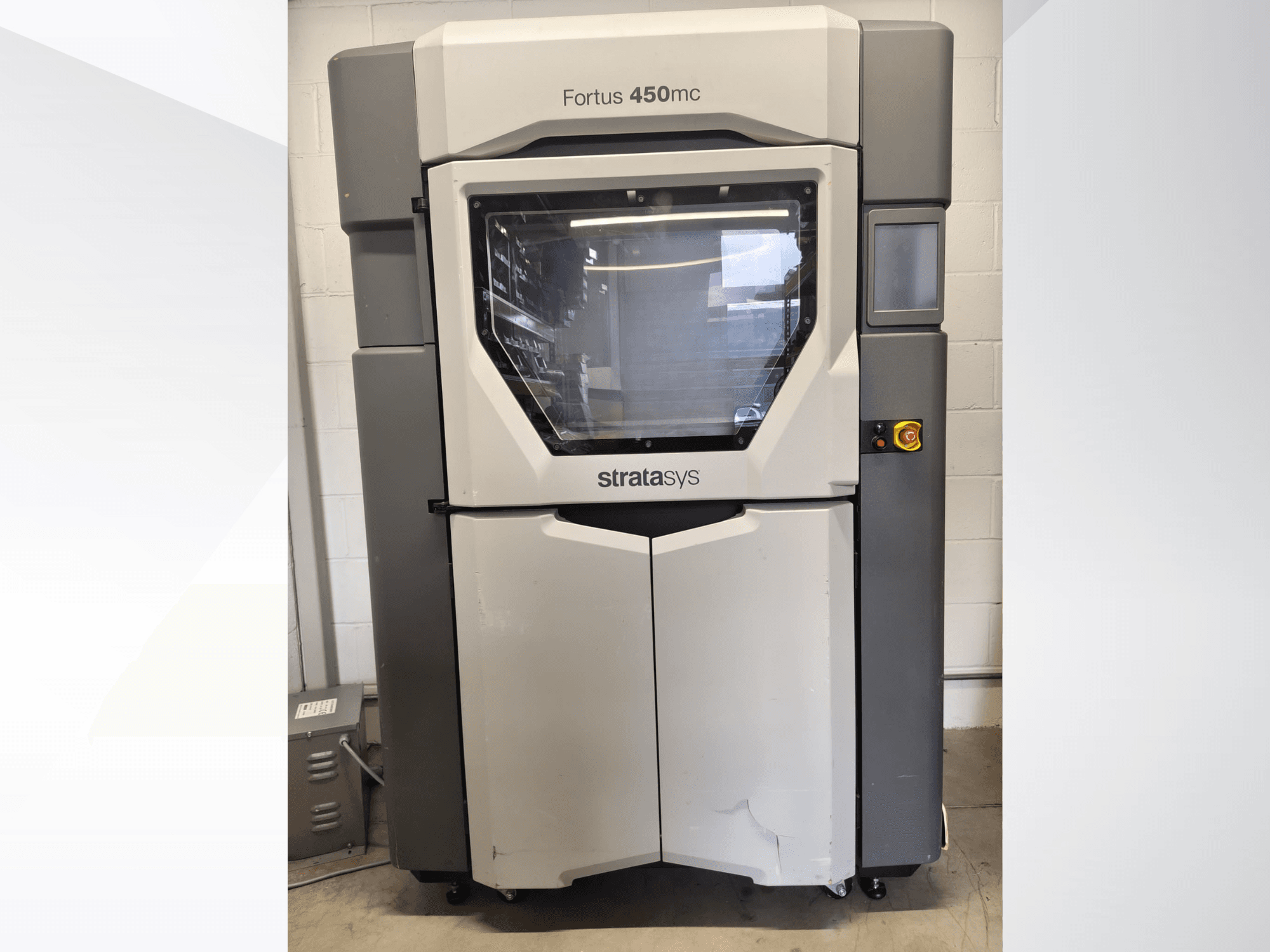 Stroj za obradu plastike Stratasys Fortus 450mc, prednji pogled, s velikim prozorom, upravljačkom pločom i industrijskim dizajnom.