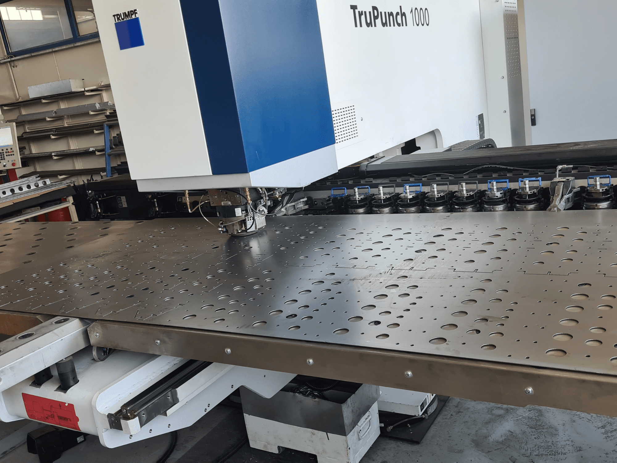 CNC stroj za probijanje TRUMPF TruPunch 1000, prednji pogled, prikazuje perforirani metalni lim i postavu alata.