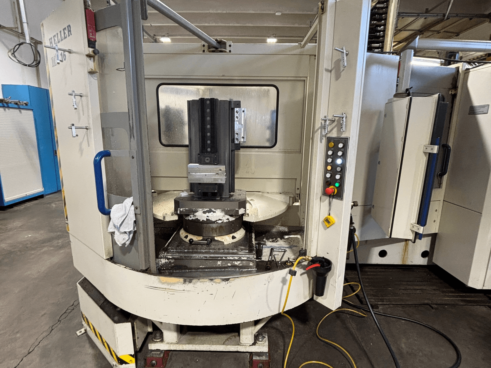 Heller obradni centar, vertikalni model, prednji pogled koji prikazuje vreteno, upravljačku ploču i radni stol s priključenom opremom.