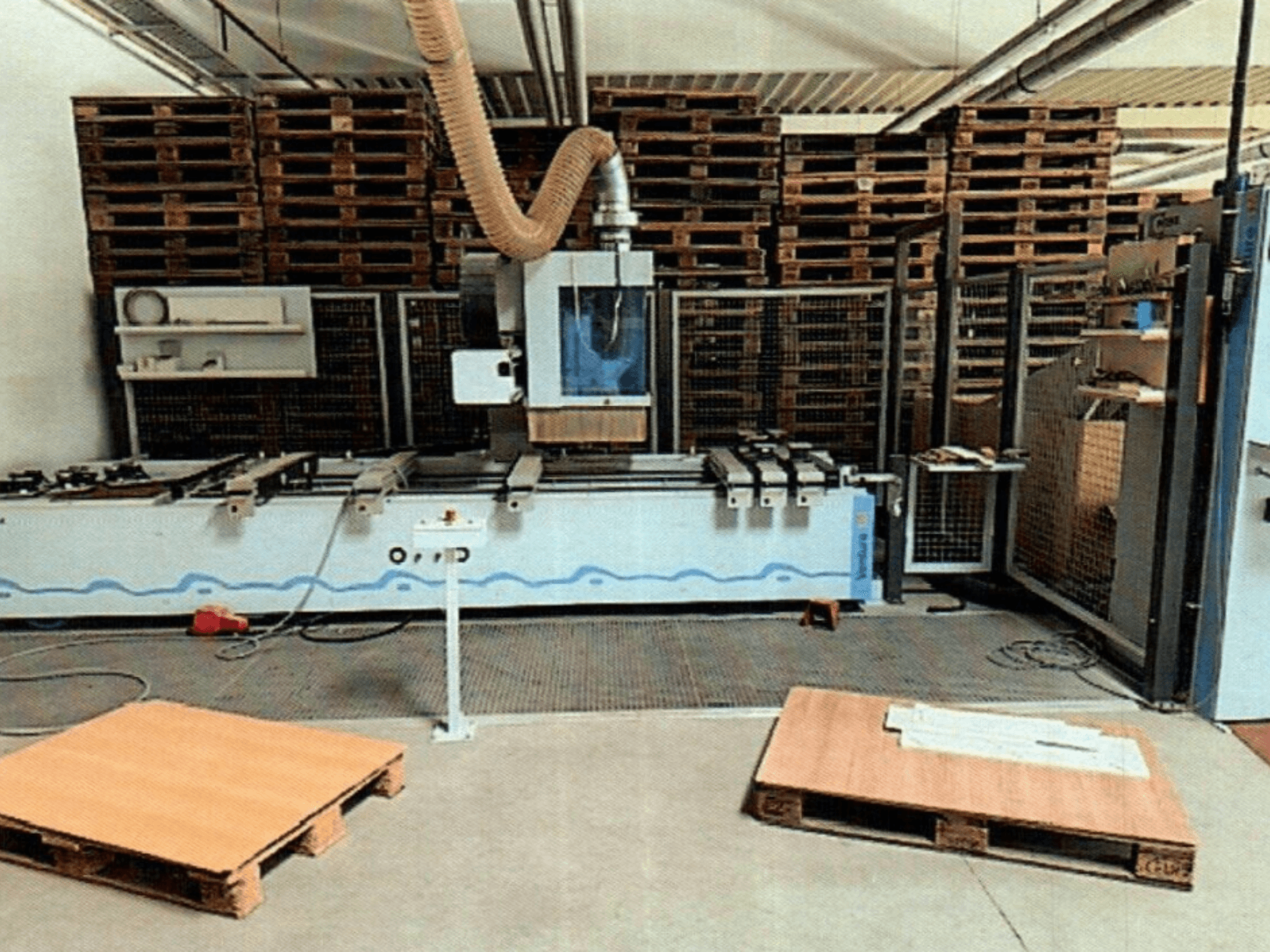 CNC centar za obradu drva Weeke Venture 1M u radionici, prednji pogled s vidljivim drvenim paletama i industrijskim postavom.