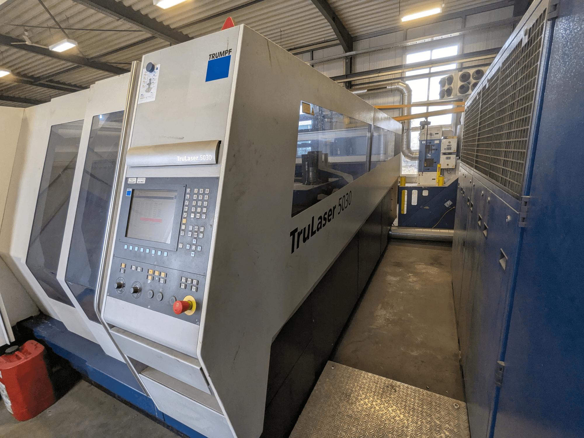 TRUMPF TruLaser 5030 CO2 stroj za lasersko rezanje, prednji pogled s upravljačkom pločom i elegantnim dizajnom, u industrijskom okruženju.