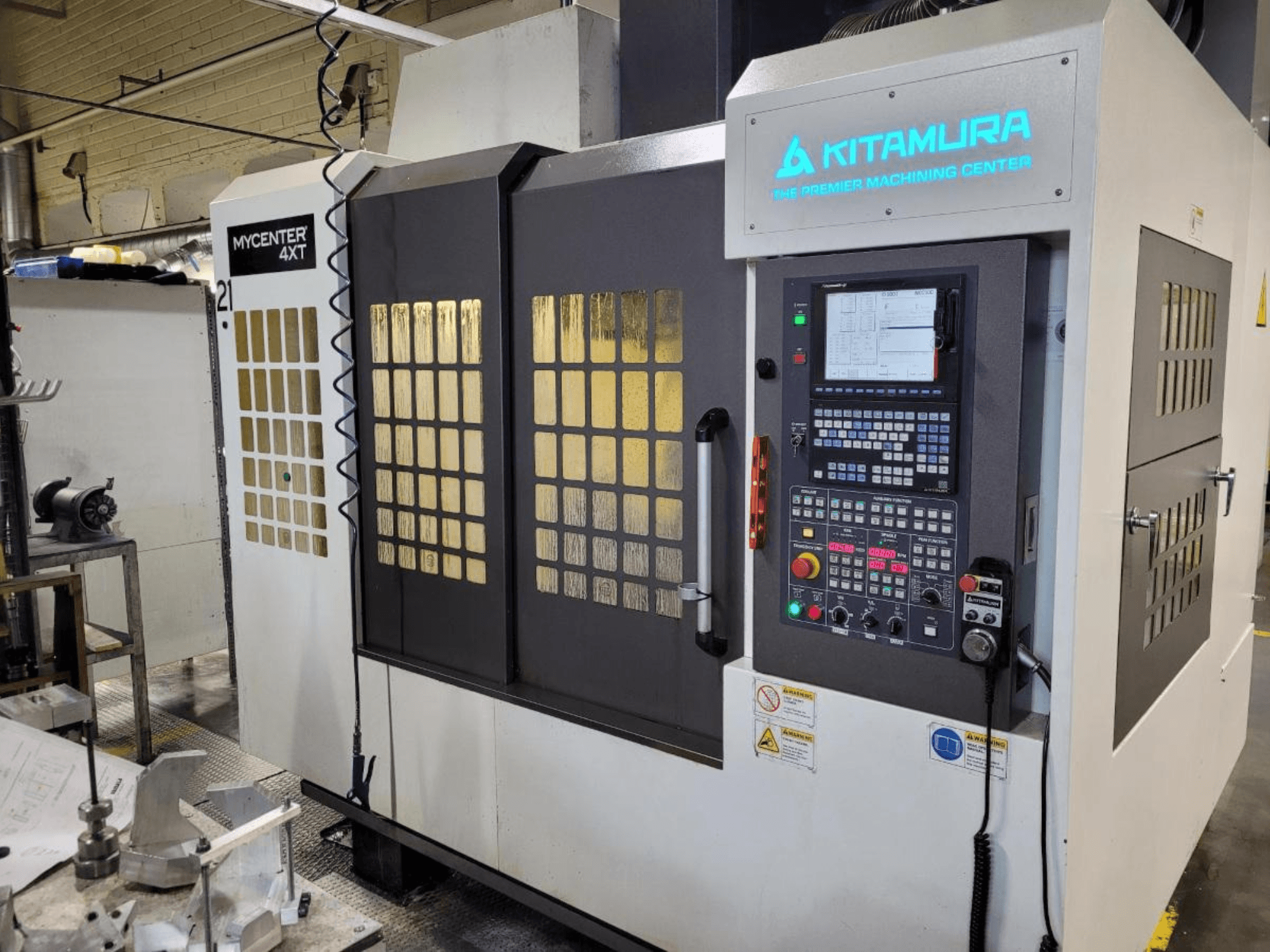 Vertikalni pogled na obradni centar Kitamura Mycenter-4XT, s upravljačkom pločom i osvijetljenim brendiranjem.
